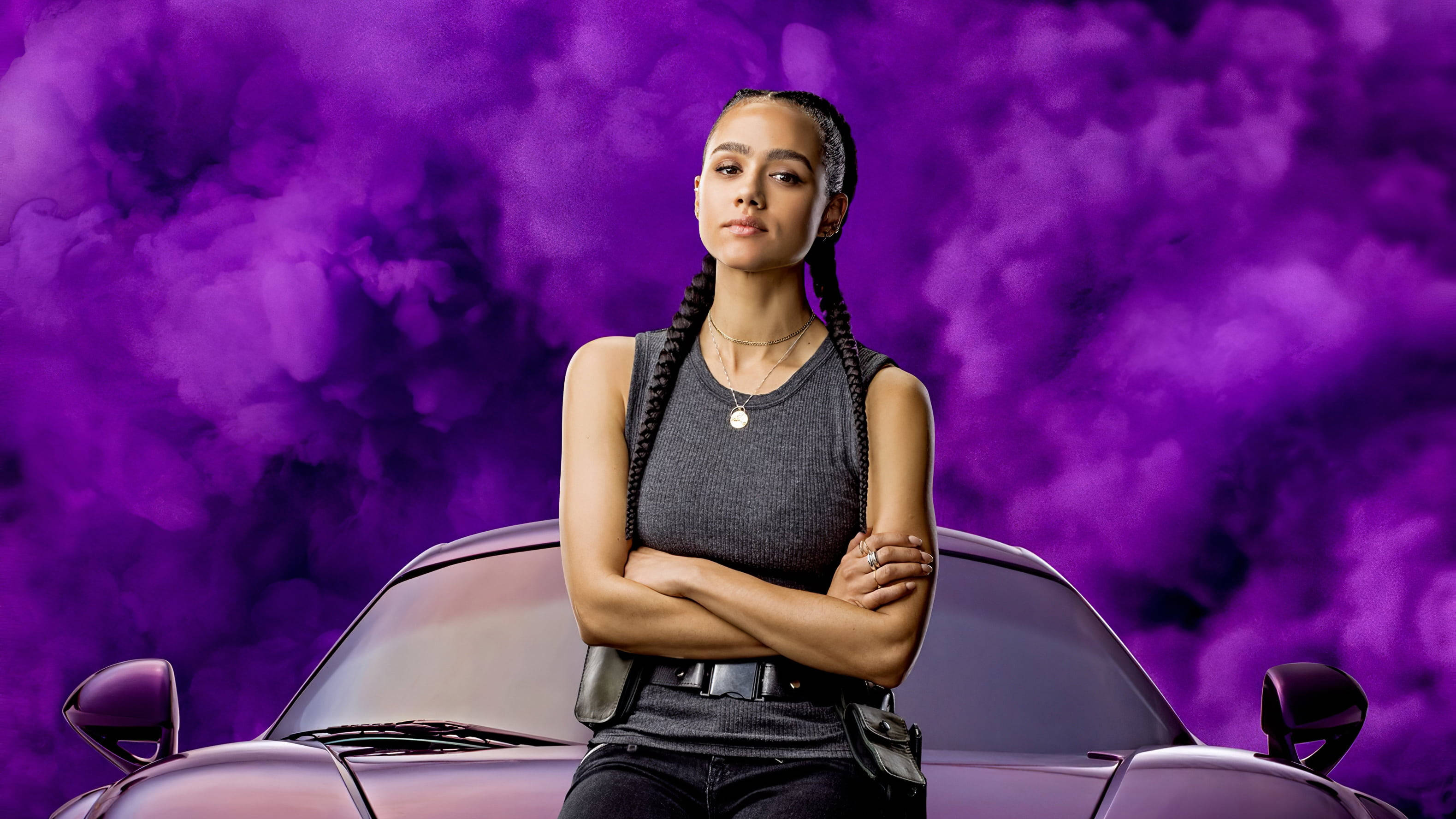 Fast And Furious 桌布 壁紙 — 一位自信的辮子女性雙臂交叉，站在一輛時尚的紫色跑車上，背景是旋轉的紫色煙霧。
