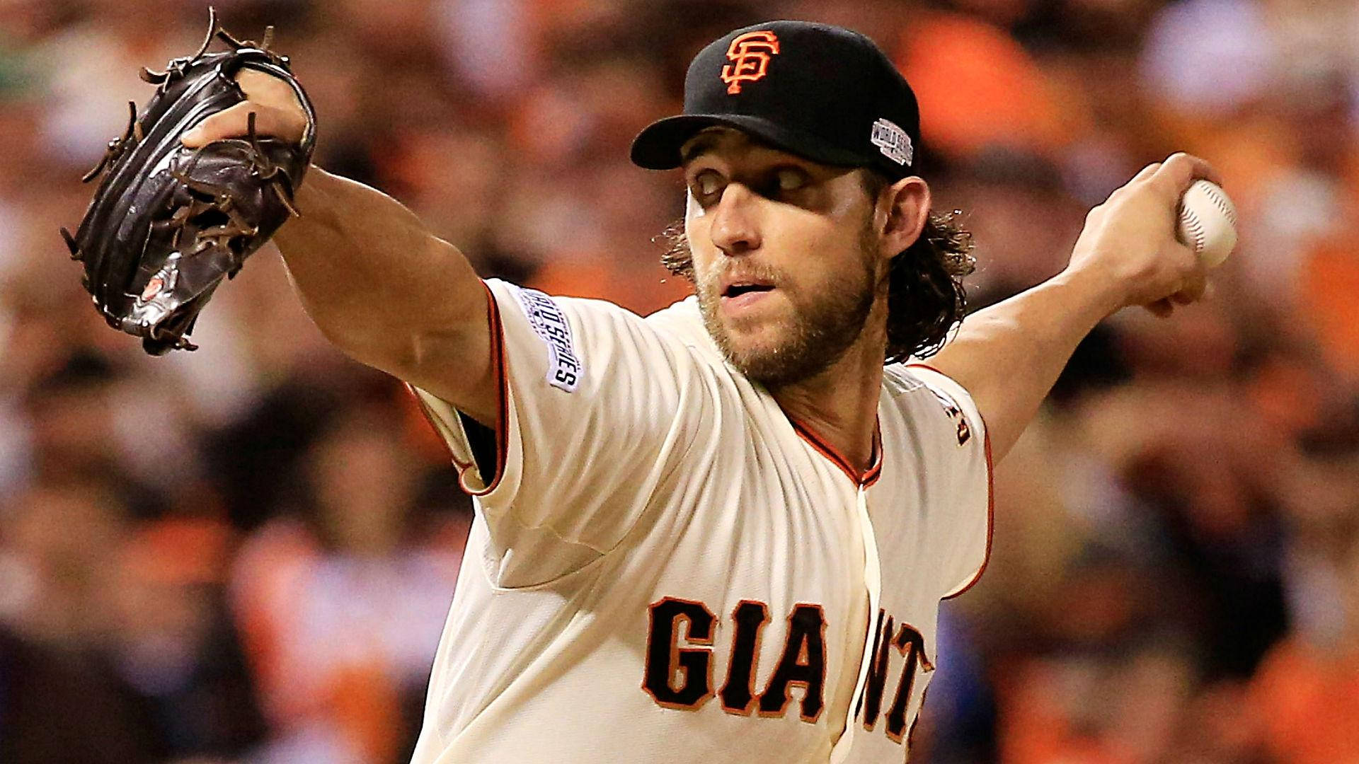 madison bumgarner 桌布 壁紙 — 一位舊金山巨人隊投手在夜間比賽中投球，背後是模糊的橙色人群。