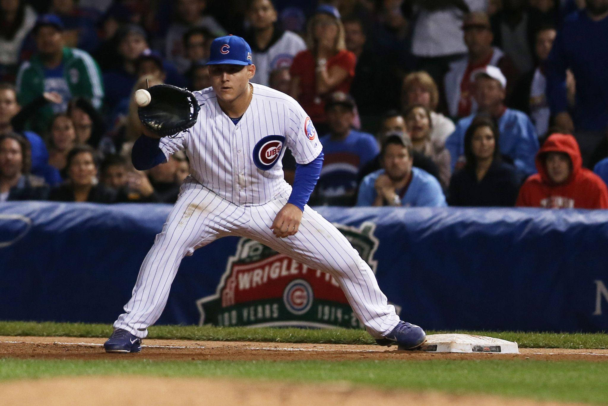運動 桌布 壁紙 — 一位芝加哥小熊隊棒球運動員穿著條紋制服，在夜間比賽中向壘包投球，背景有球迷。