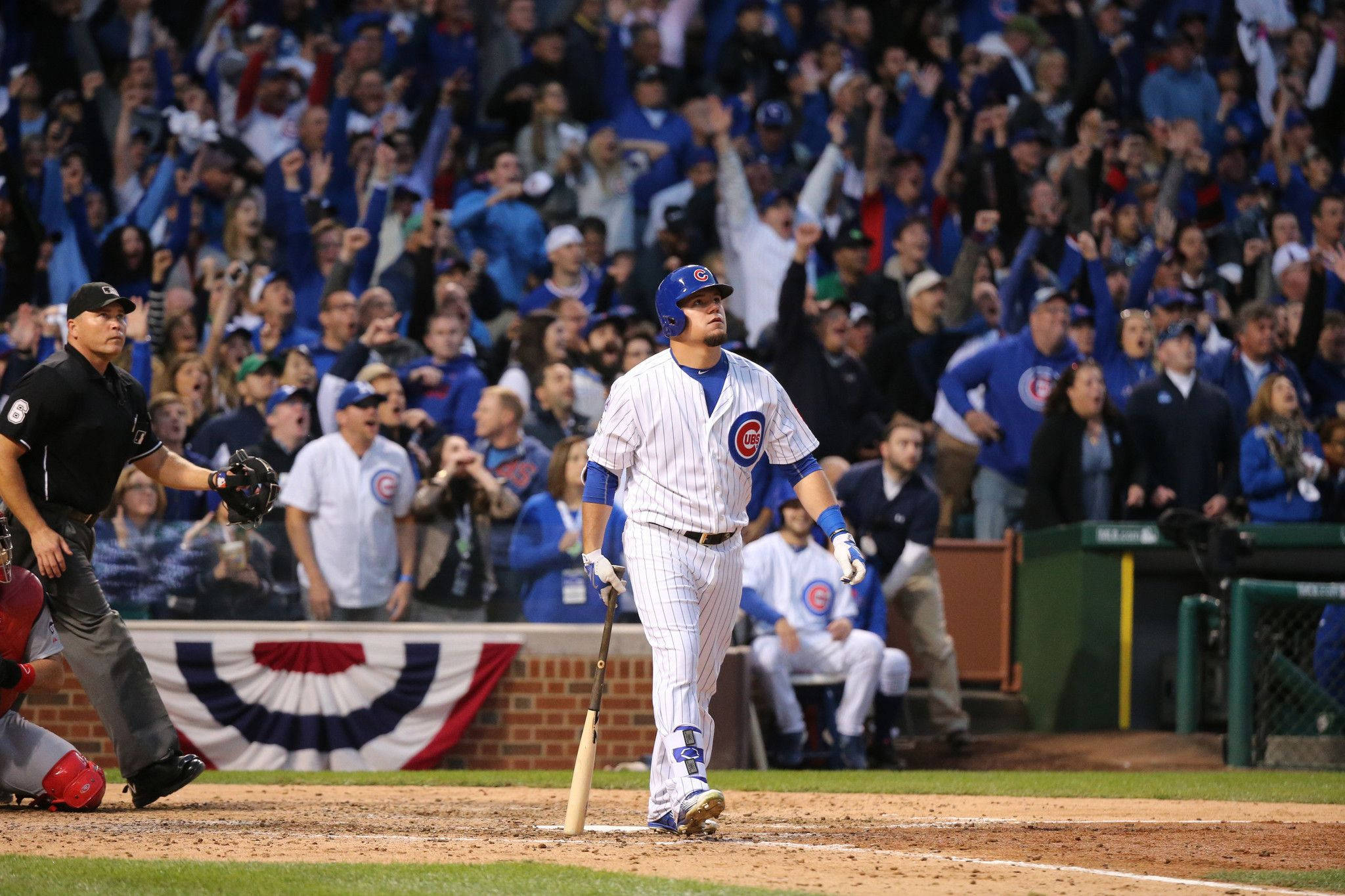 MLB 桌布 壁紙 — 一位芝加哥小熊隊棒球選手站在本壘板，手持球棒，裁判和捕手在夜間比賽中觀看，背景是歡呼的人群。