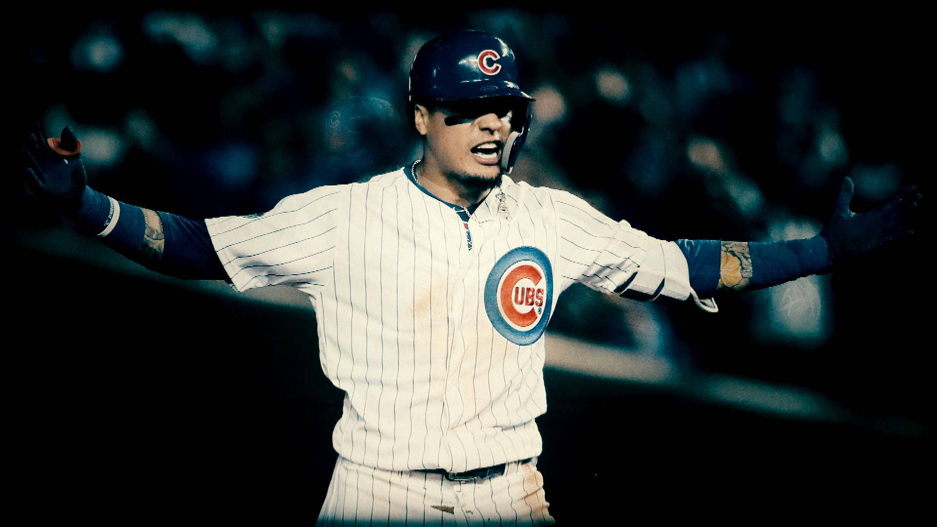 Baez 桌布 壁紙 — 一位芝加哥小熊隊的棒球選手穿著細條紋制服，在夜間球場燈光下張開雙臂慶祝。