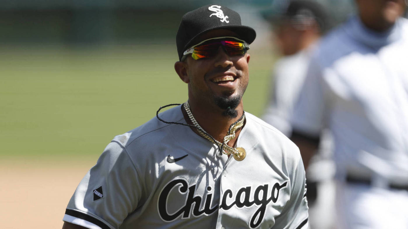 jose abreu 桌布 壁紙 — 一位芝加哥白襪隊的棒球運動員在陽光明媚的球場上戴著太陽眼鏡和金色項鍊，露出燦爛的笑容。