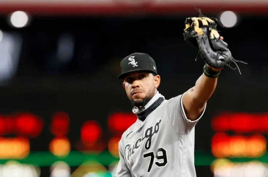 jose abreu 桌布 壁紙 — 一位芝加哥白襪隊的棒球選手穿著灰色球衣，在明亮的燈光下於球場舉起手套。
