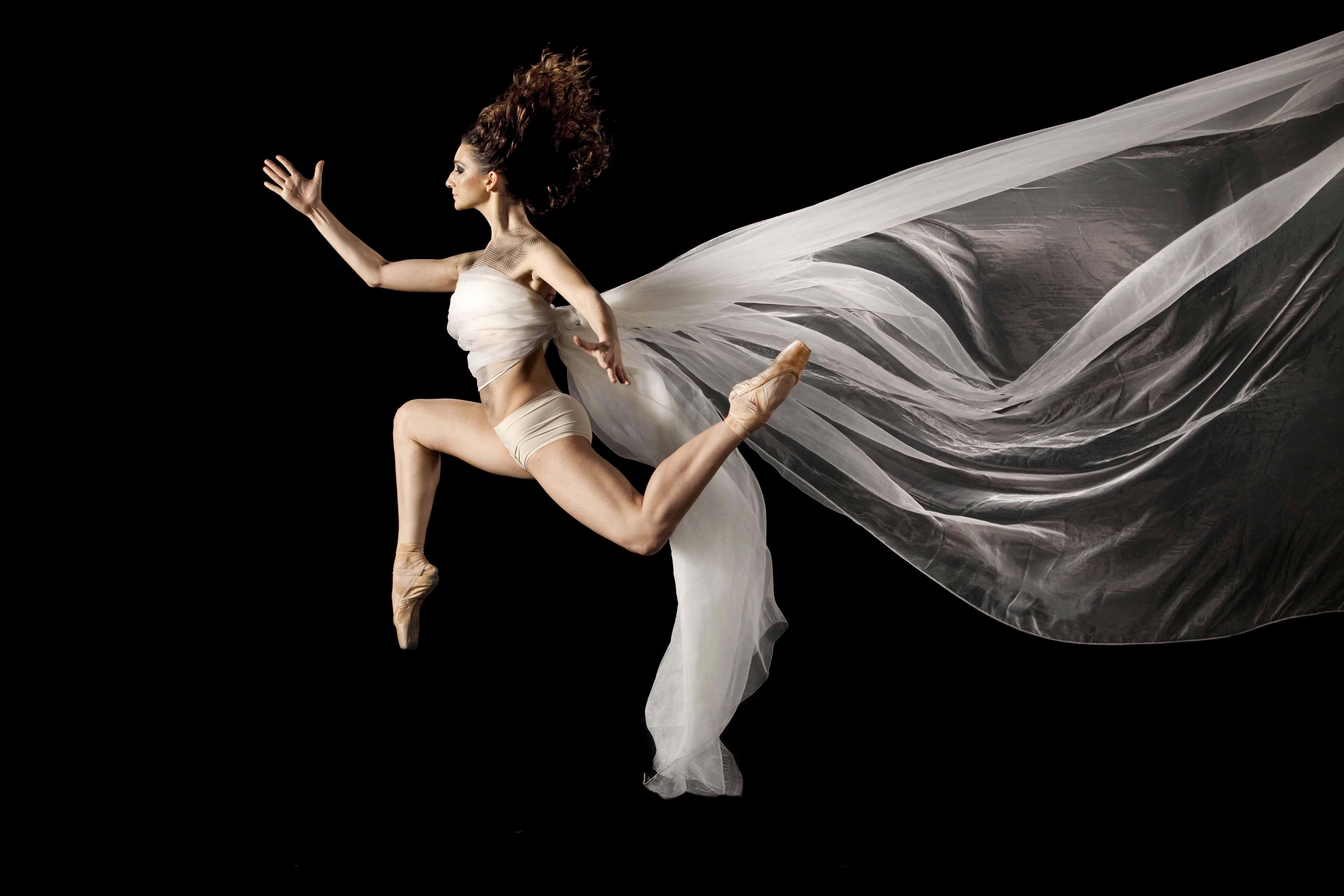 Ballet Dancer 桌布 壁紙 — 一位芭蕾舞者在黑色背景下動態跳躍，身後飄逸著白色面紗。