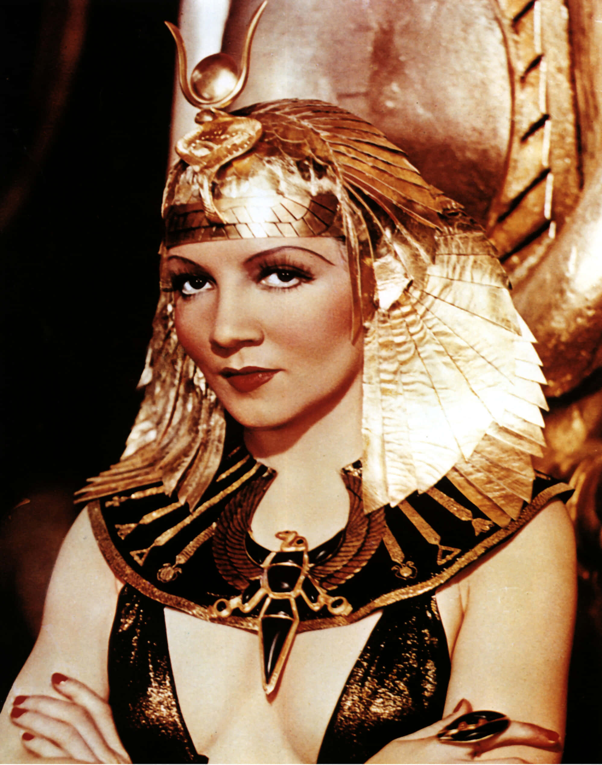 Cleopatra 桌布 壁紙 — 一位華麗的女性身穿華麗的金色埃及服飾，頭戴頭飾和項鍊，自信地凝視鏡頭。