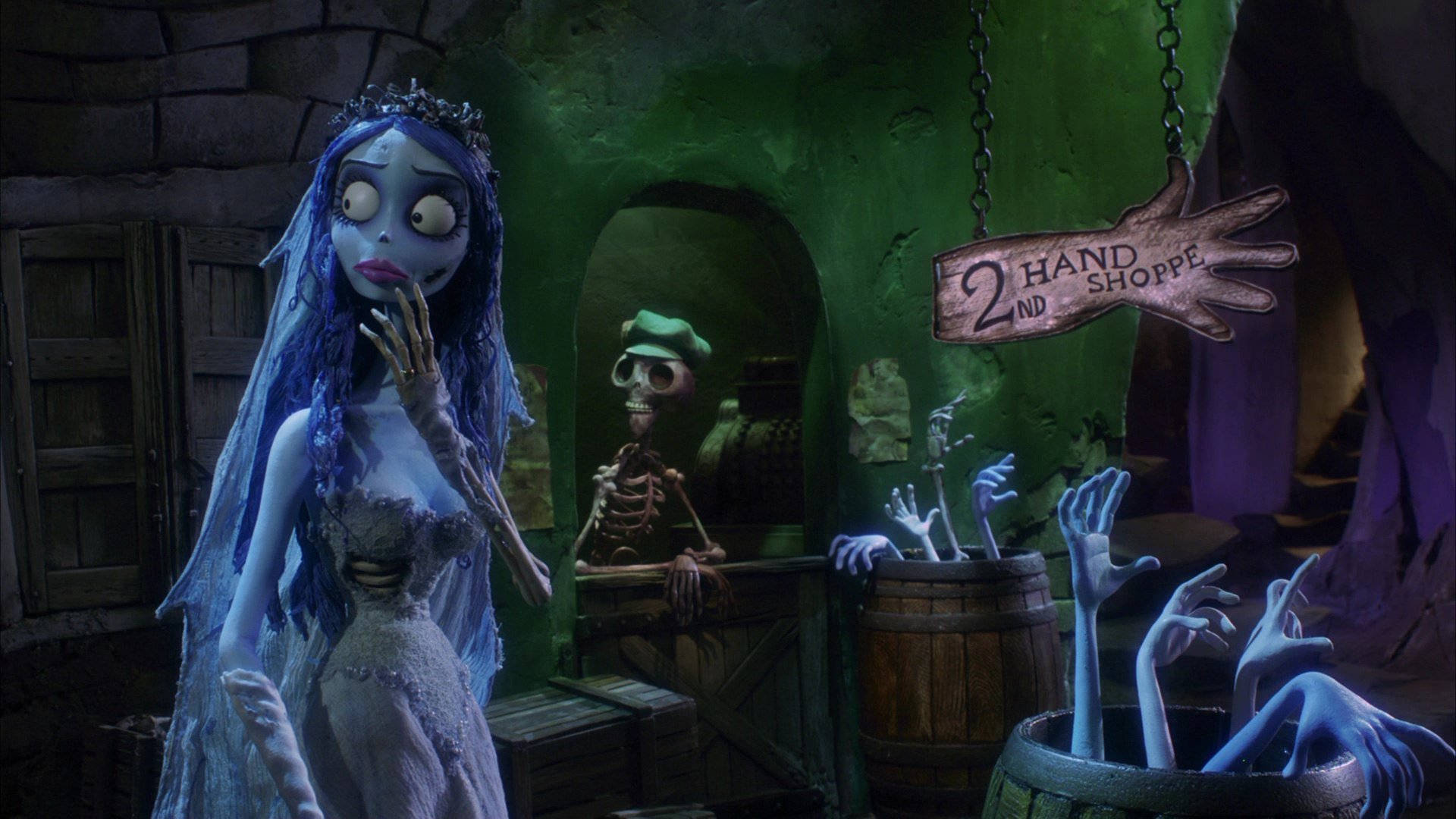 tim burton movies 桌布 壁紙 — 一位蒼白藍髮的新娘戴著皇冠，站在一個陰森的綠色洞穴商店裡，裡面有骷髏工作人員和漂浮在桶中的手。