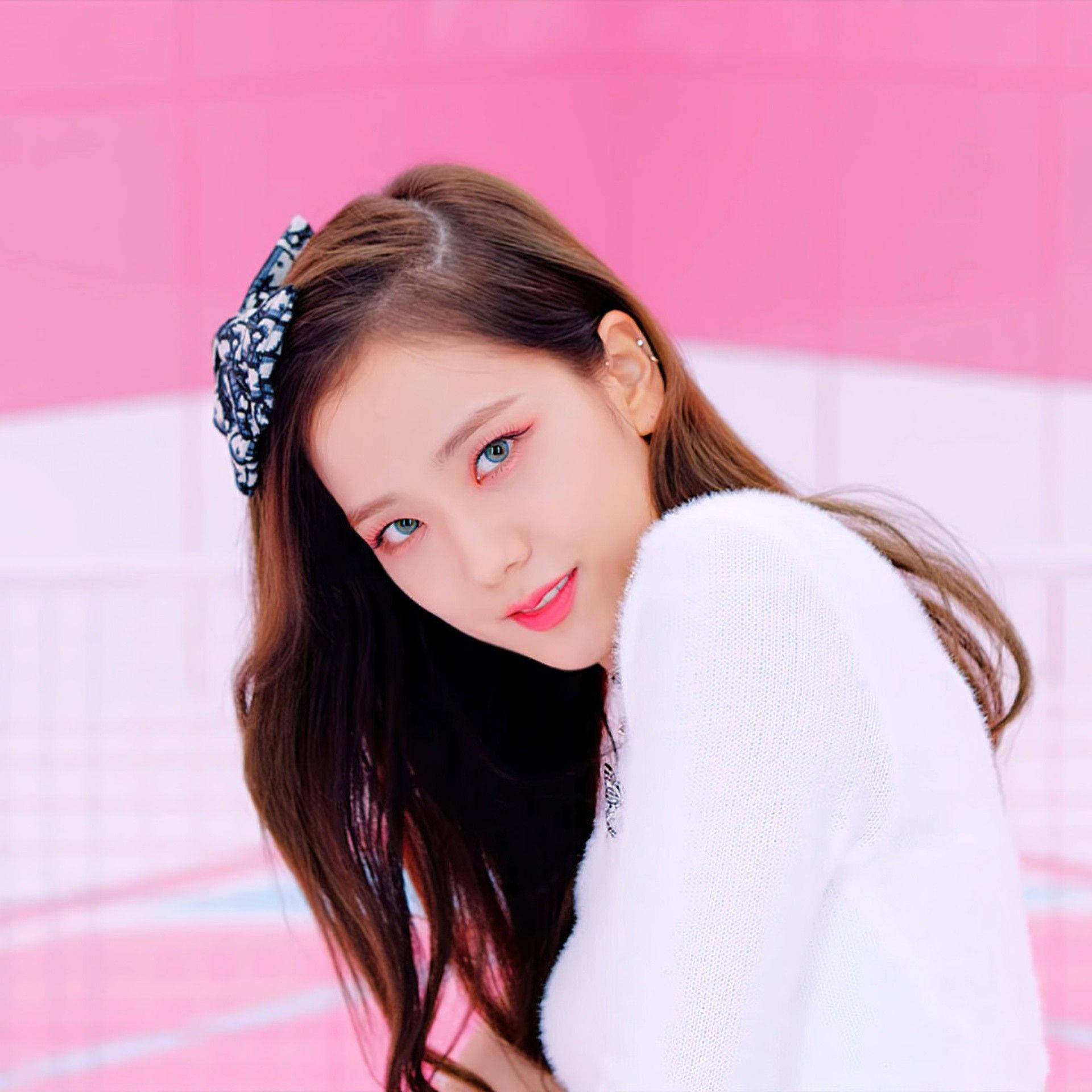 BLACKPINK 桌布 壁紙 — 一位藍眼睛、塗粉紅色口紅的年輕女性，穿著白色針織毛衣和圖案髮夾，柔和地凝視著充滿活力的粉紅色瓷磚牆。