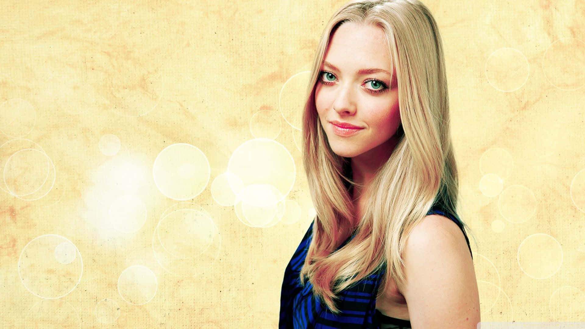 Amanda Seyfried 桌布 壁紙 — 一位藍眼睛的金髮女性在溫暖的紋理背景和發光的散景圓圈中溫柔地微笑。