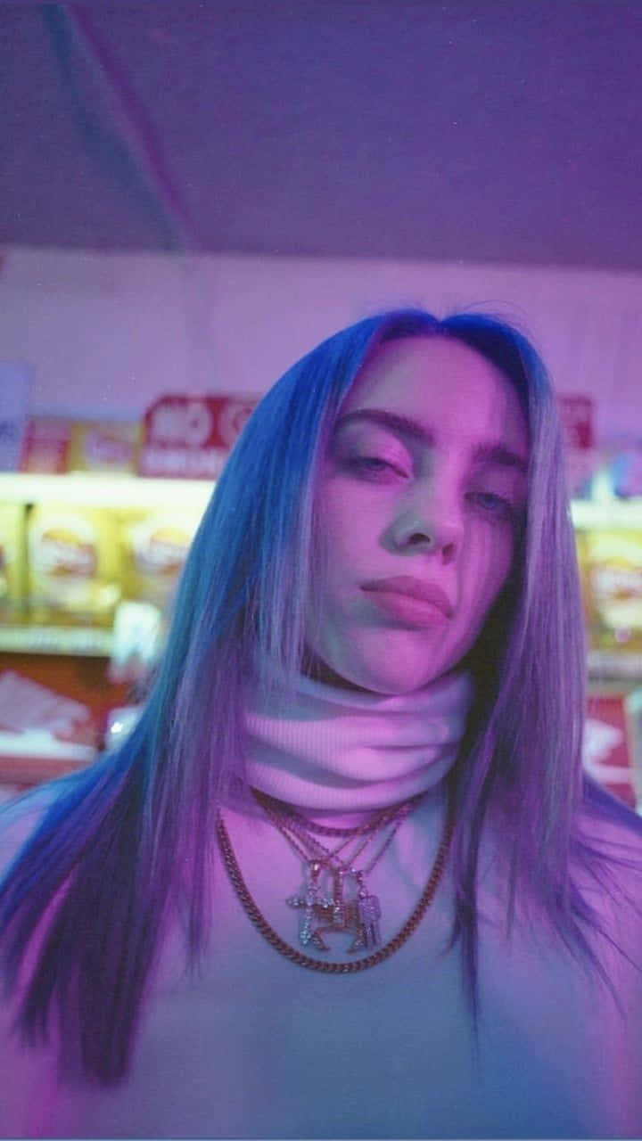 Billie Eilish Purple 桌布 壁紙 — 一位藍髮年輕女性在霓虹燈照亮的便利店通道中，沐浴在紫色和粉紅色的燈光下，茫然地凝視著。