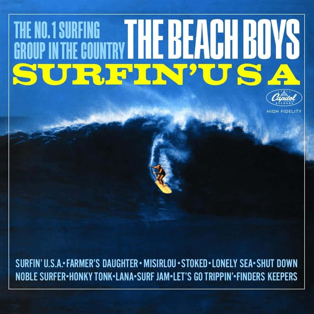 Album Cover 桌布 壁紙 — 一位衝浪者在巨大的藍色波浪上衝浪，下方有 The Beach Boys Surfin' USA 的粗體專輯文字。