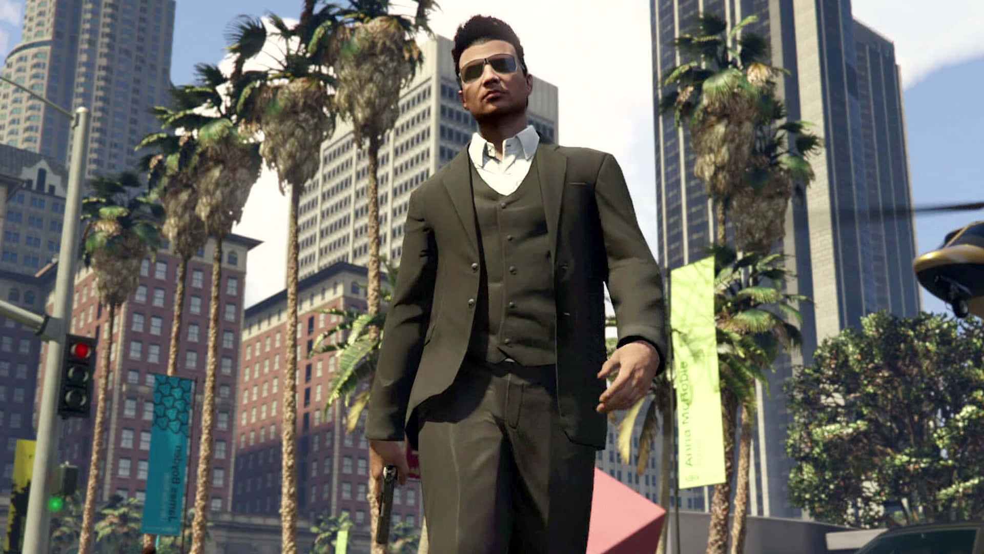 Gta Online 桌布 壁紙 — 一位衣著講究、身穿深色西裝和太陽眼鏡的男子，自信地走在一條陽光普照的都市街道上，街道兩旁種滿棕櫚樹和高聳的摩天大樓。