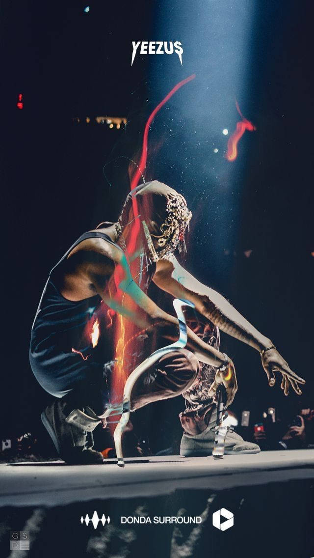 Kanye 桌布 壁紙 — 一位表演者戴著金屬面具和發光的紅色能量痕跡，在戲劇性的聚光燈下動態地蹲在黑暗的舞台上。
