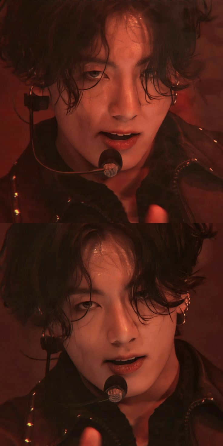 Jungkook 桌布 壁紙 — 一位表演者濕著深色頭髮在溫暖的紅色舞台燈光下對著麥克風唱歌的特寫。