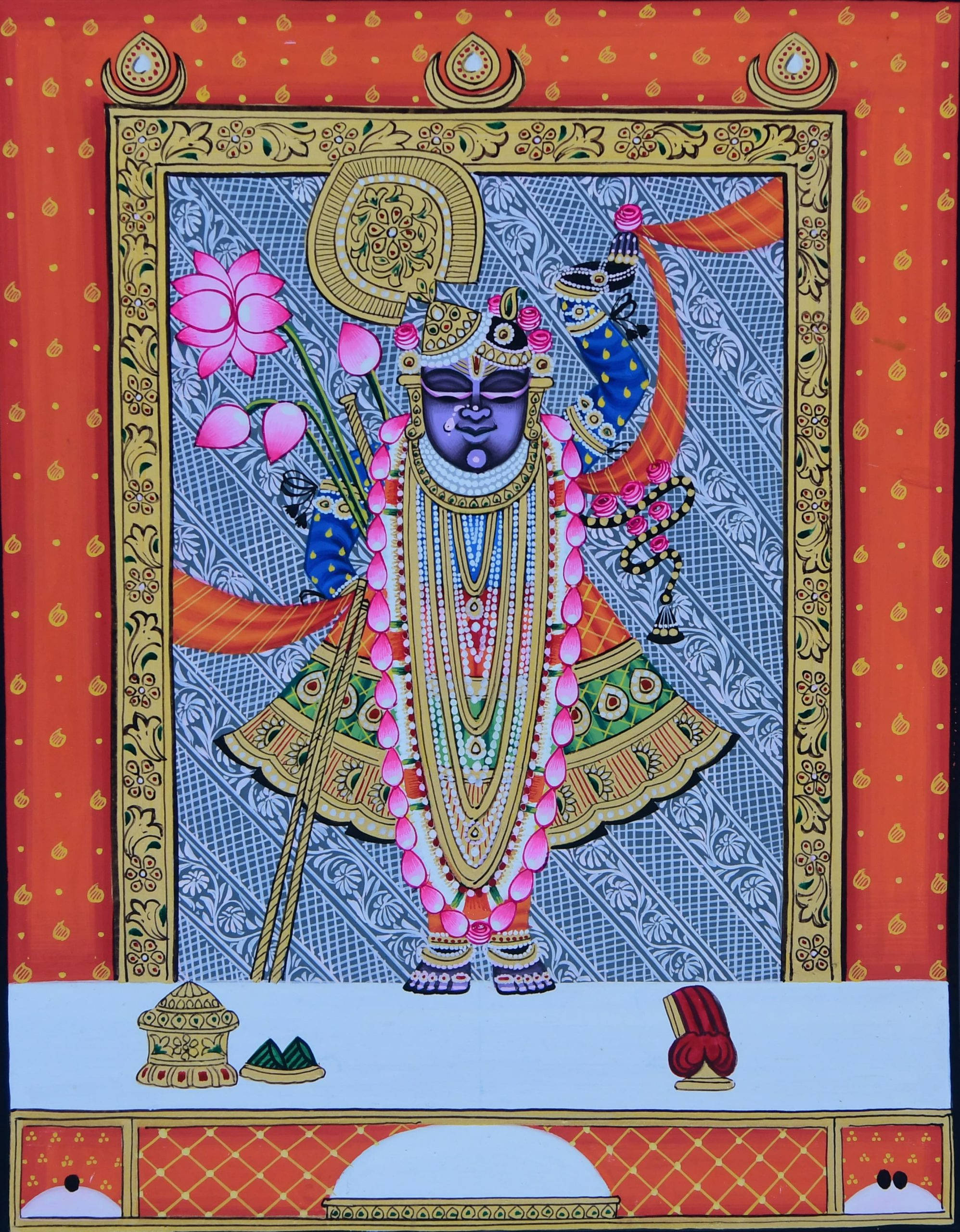 Shrinathji 桌布 壁紙 — 一位裝飾華麗的印度教神祇，紫色皮膚，威嚴地站在華麗的金色和紅色框架中，手持蓮花和金剛杵，背景為圖案化的藍色。