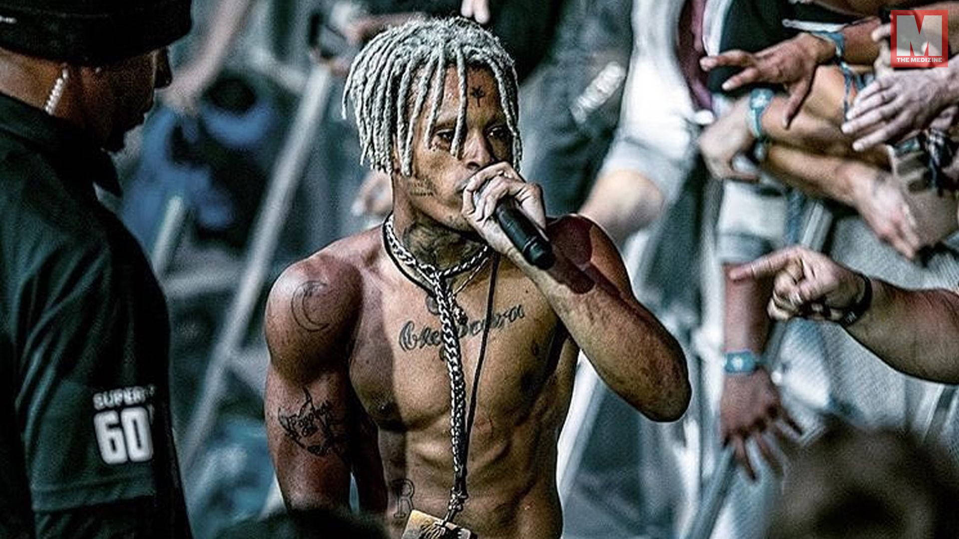 xxxtentacion 電腦 桌布 壁紙 — 一位赤裸上身的說唱歌手，梳著辮子頭，身上有刺青，在伸出的粉絲包圍下對著麥克風表演。