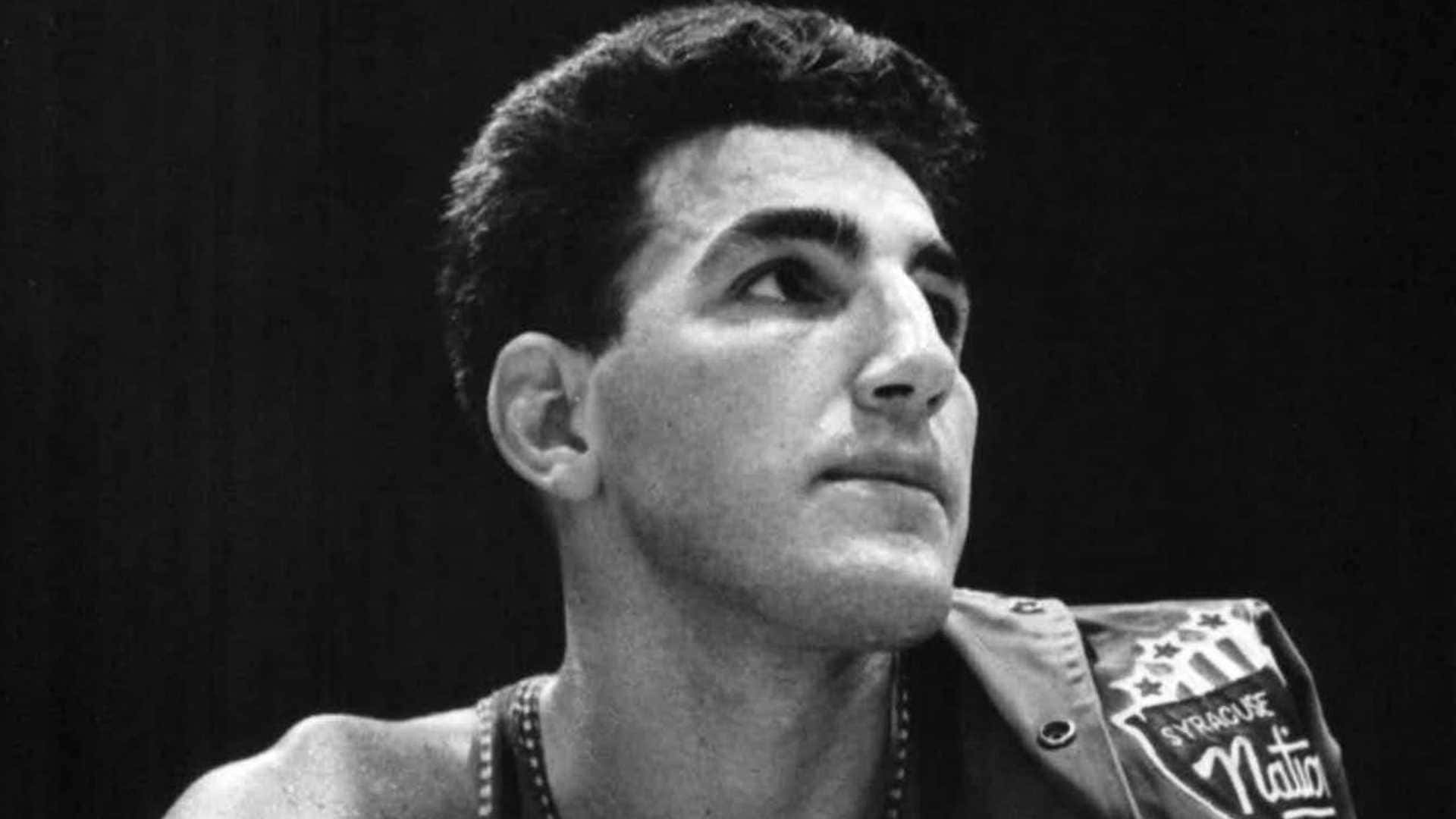 一位身穿 Syracuse Nation 外套的年輕籃球運動員的肖像，他正向上仰望。 — NBA 壁紙