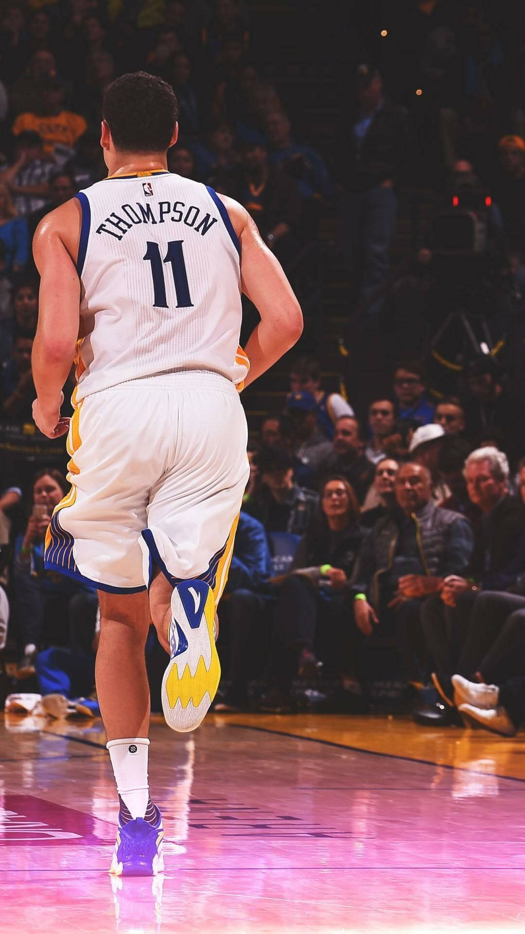 Thompson 桌布 壁紙 — 一位身穿11號球衣的籃球運動員在燈光明亮的球場上奔跑，背景有觀眾。