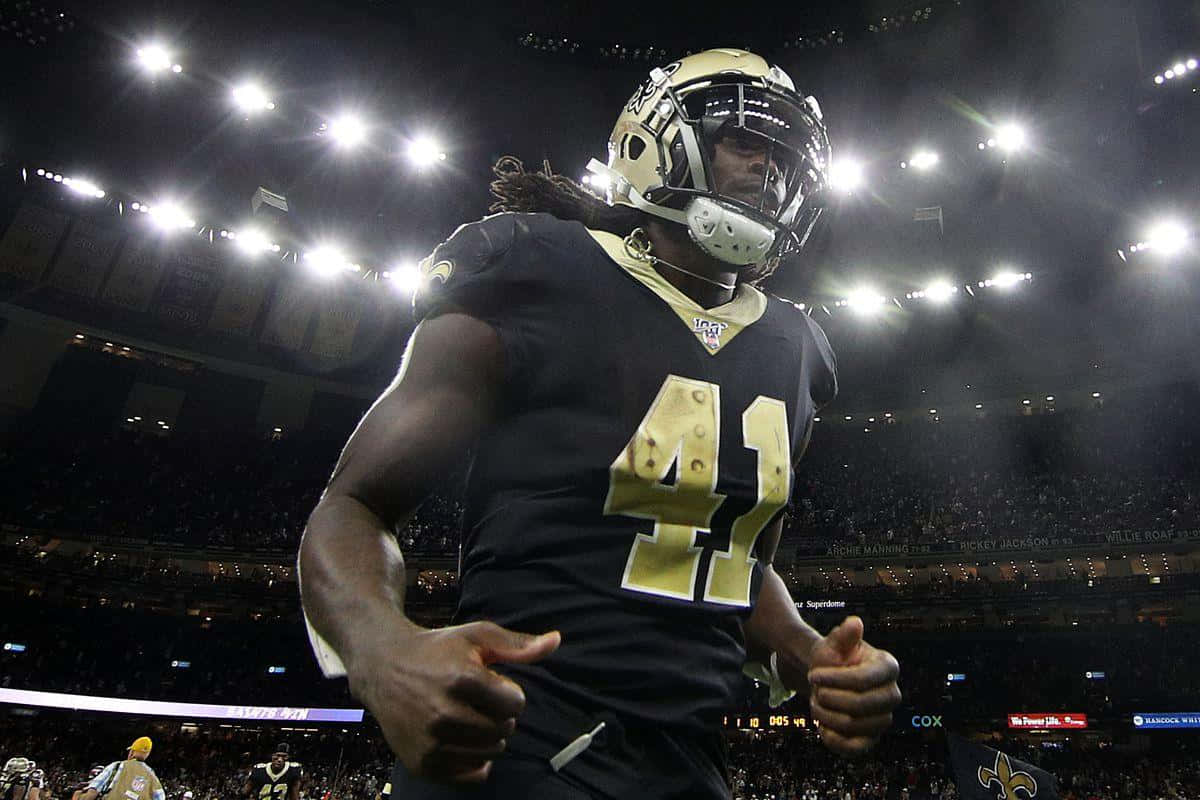 Alvin Kamara 桌布 壁紙 — 一位身穿41號球衣的紐奧良聖徒隊美式足球員在夜間比賽中於球場燈光下豎起大拇指慶祝。