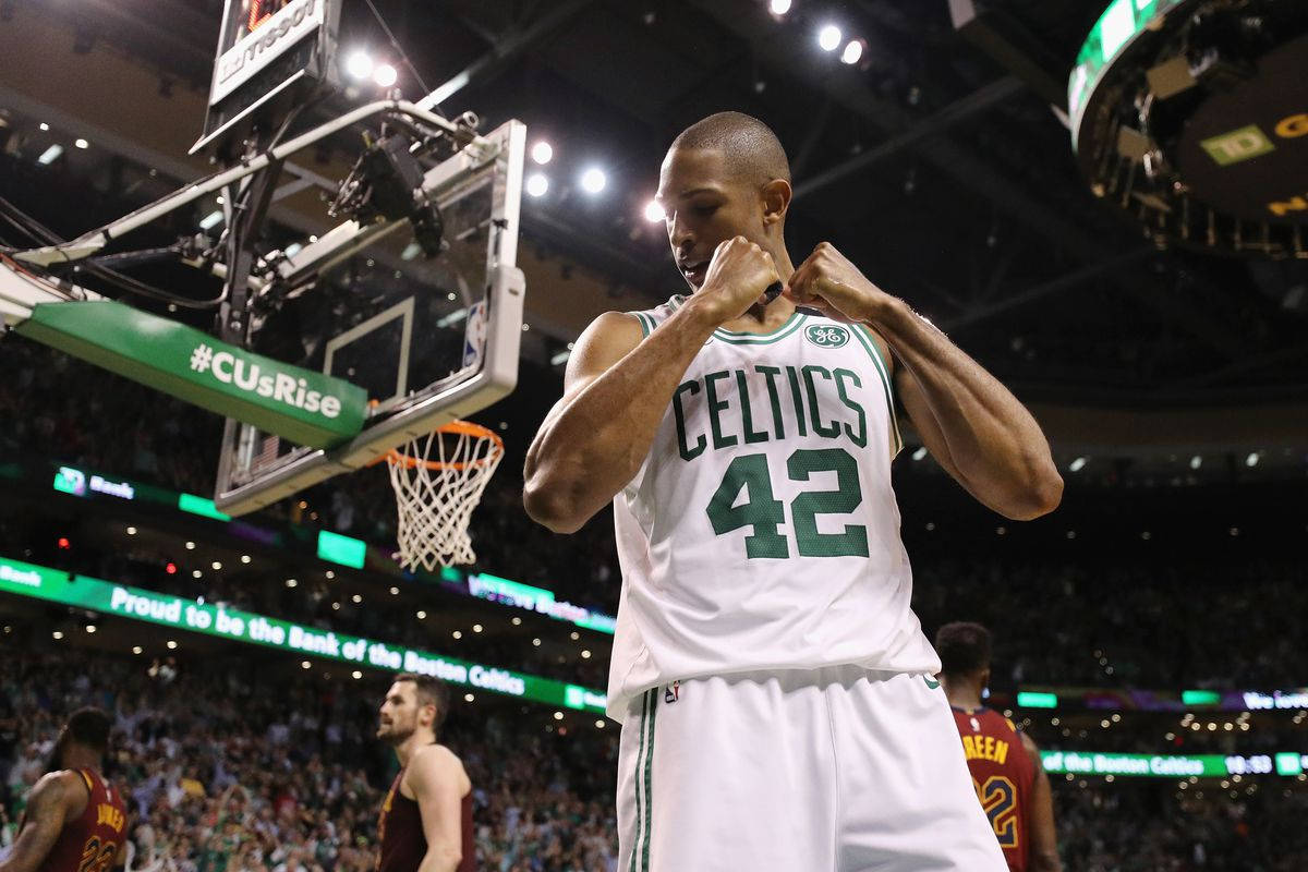 Al Horford 桌布 壁紙 — 一位身穿42號球衣的波士頓塞爾提克籃球運動員在場館燈光下握緊拳頭慶祝勝利。