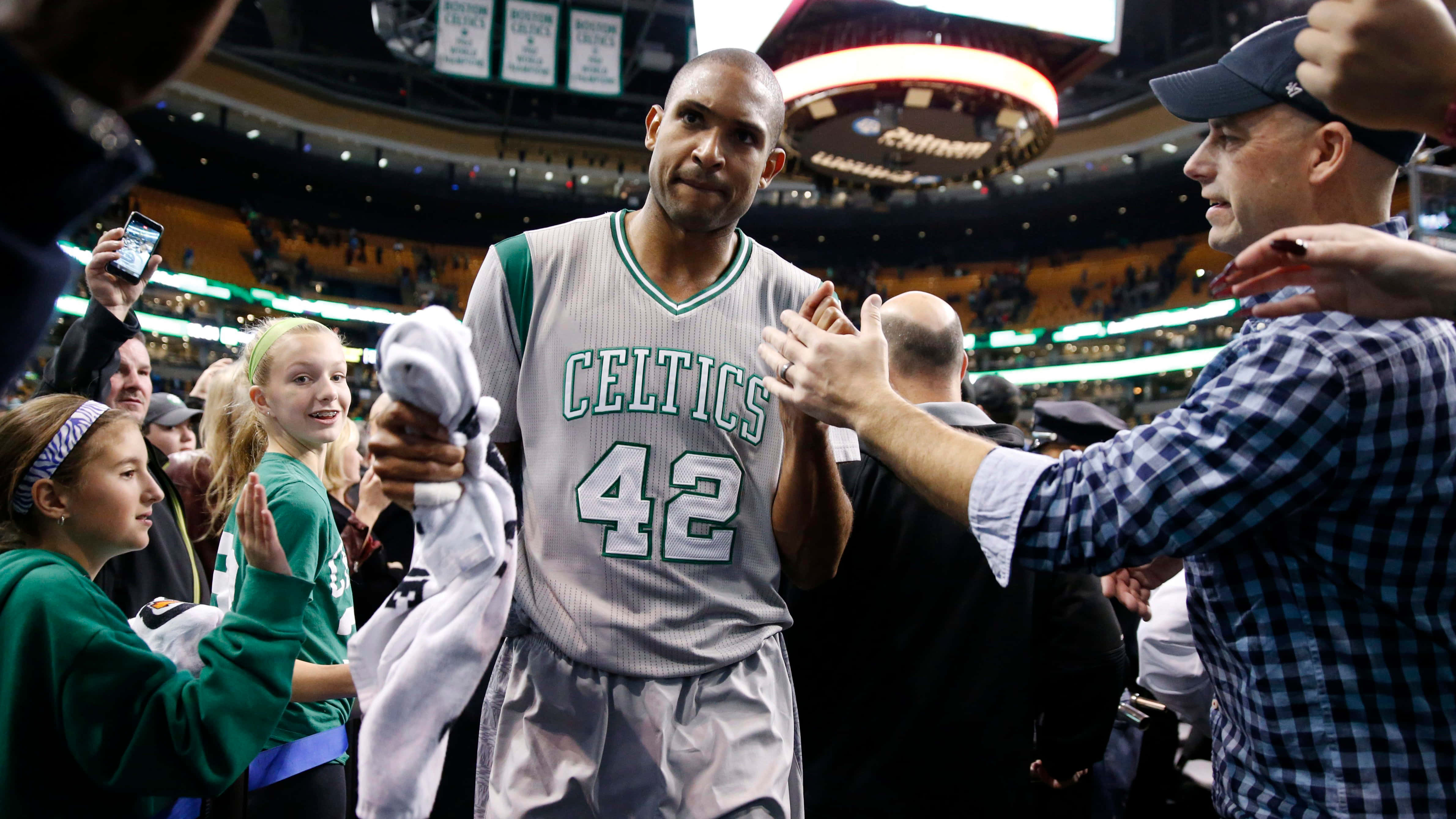 Al Horford 桌布 壁紙 — 一位身穿42號球衣的波士頓塞爾提克籃球運動員在擠滿觀眾的場館中與球迷擊掌和微笑打招呼。