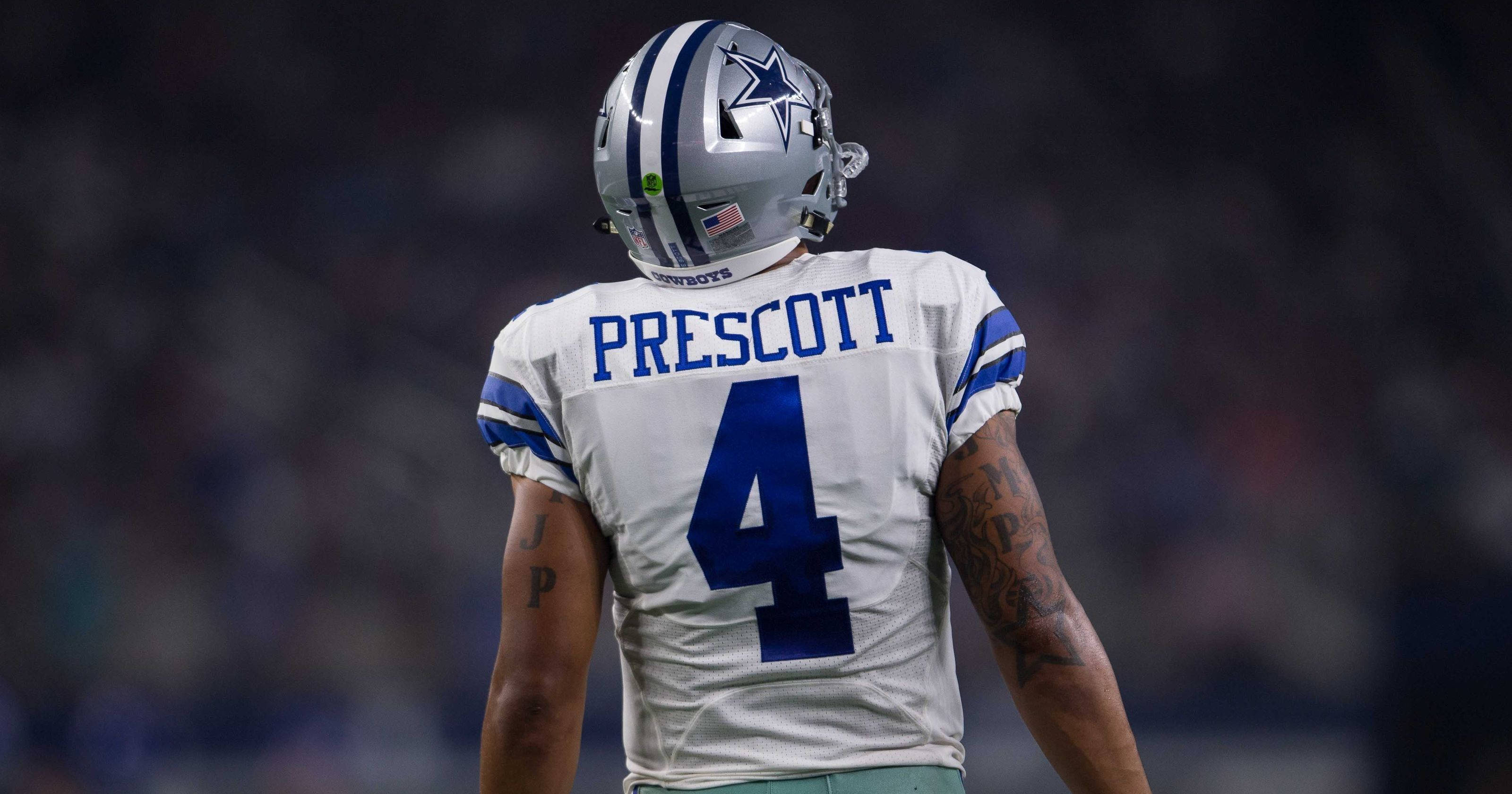 Dak Prescott 桌布 壁紙 — 一位身穿4號球衣的達拉斯牛仔隊四分衛背對鏡頭，站在模糊的球場上。