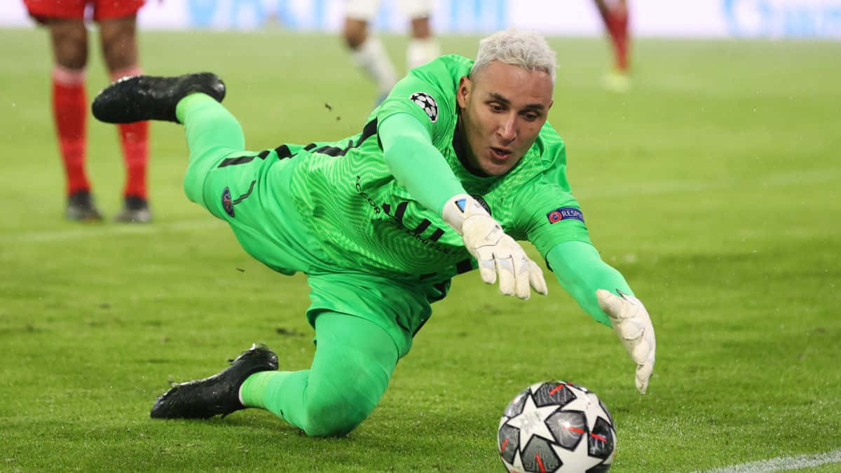Keylor Navas 桌布 壁紙 — 一位身穿亮綠色球衣的足球守門員在充滿活力的綠色球場上低身撲救，阻止歐冠比賽用球。