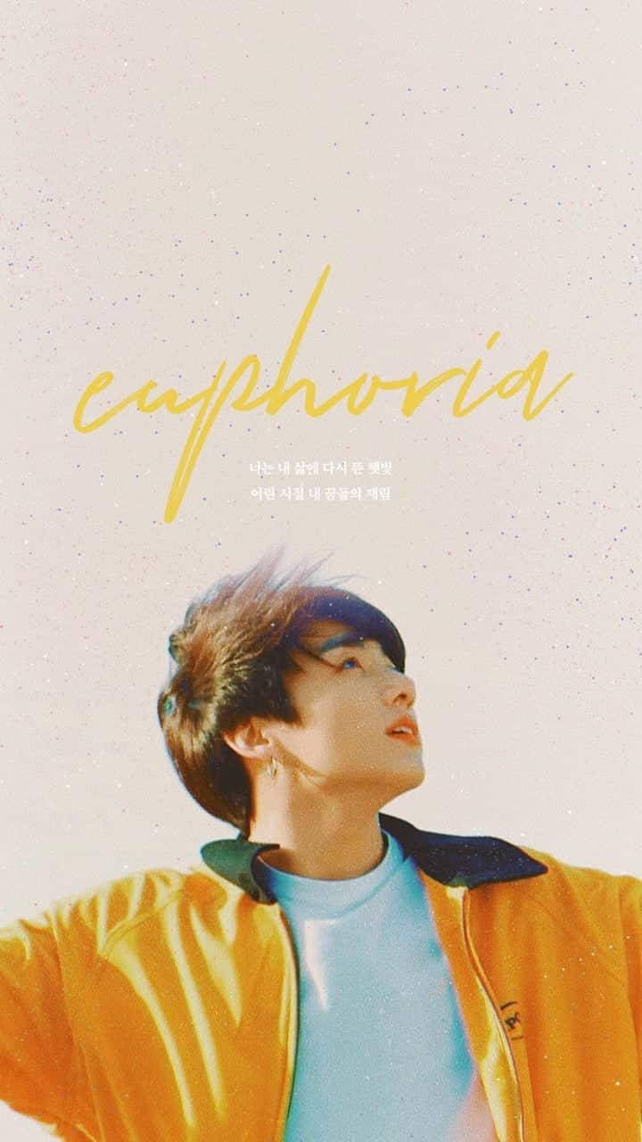 Jungkook Aesthetic 桌布 壁紙 — 一位身穿亮黃色外套的年輕男子，在柔和粉彩的天空背景下向上凝望，天空中以流暢的黃色字體寫著「euphoria」一詞。