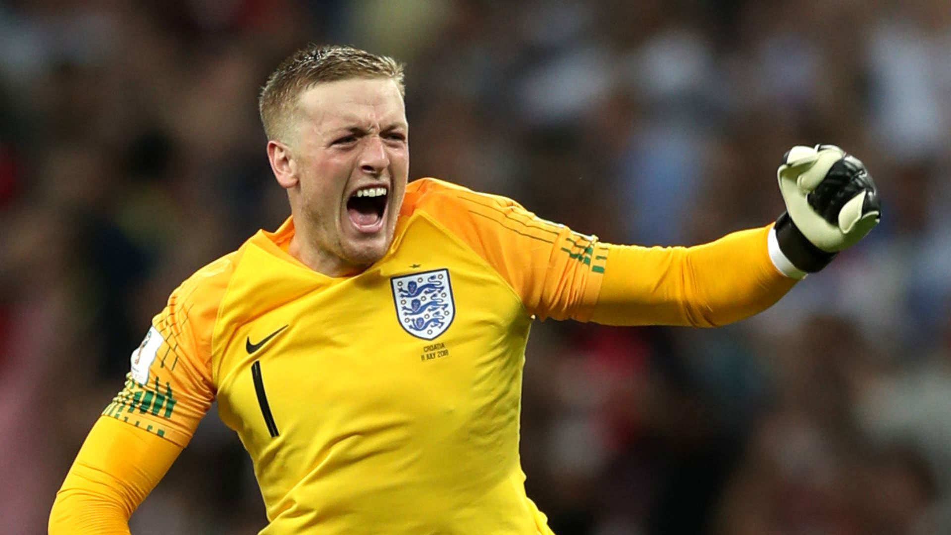 Football Players 桌布 壁紙 — 一位身穿亮黃色球衣的英格蘭門將，熱情地高舉戴著手套的手，發出勝利的咆哮。