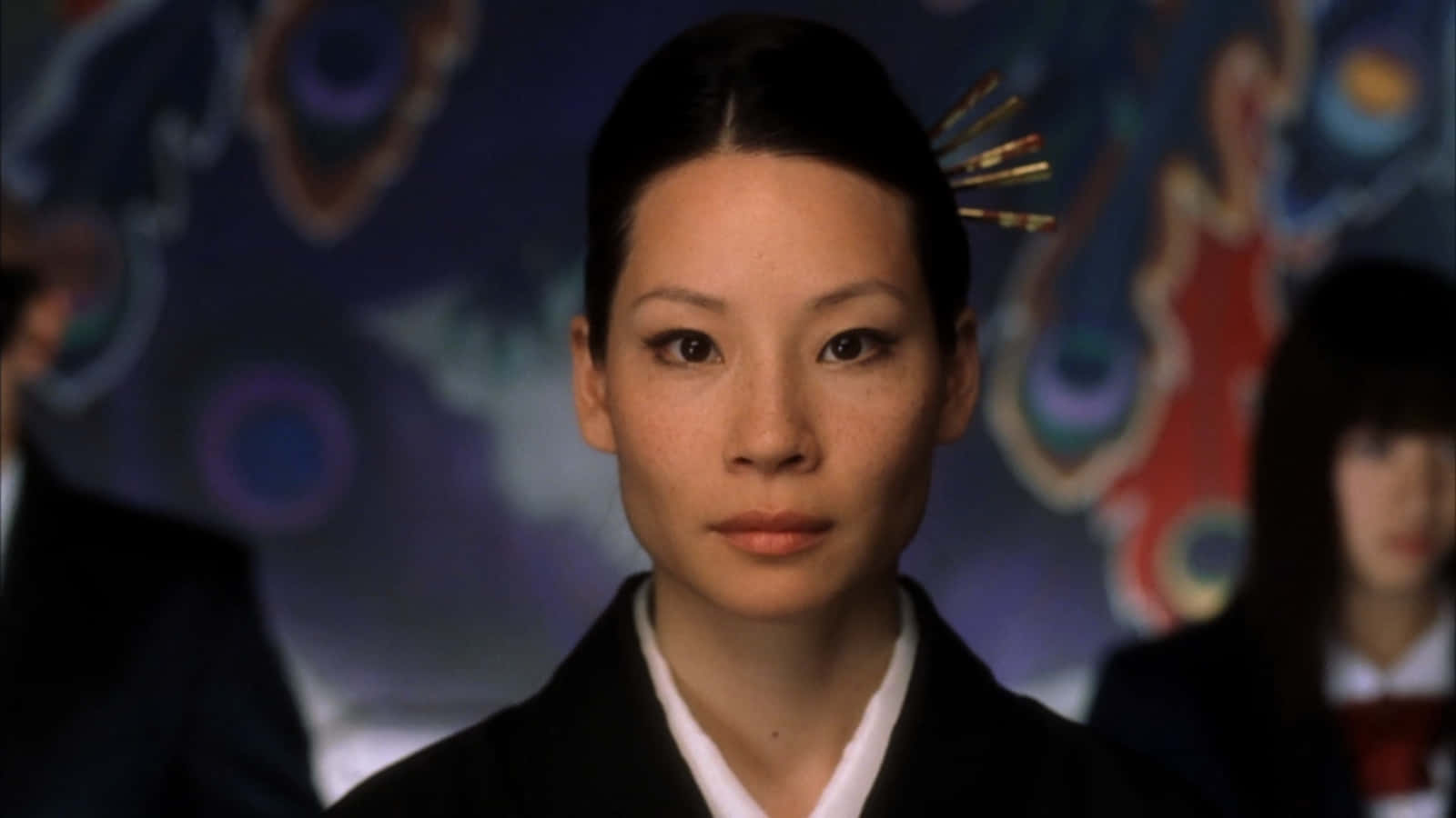 lucy liu 桌布 壁紙 — 一位身穿傳統日本服飾的女性，在充滿活力的抽象背景下，以平靜而專注的眼神向前凝視。