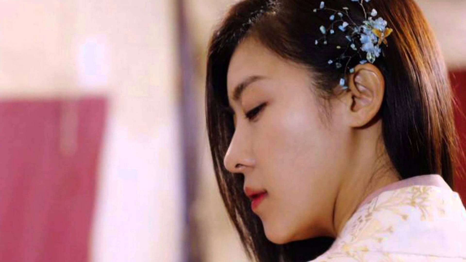 kdrama 桌布 壁紙 — 一位身穿傳統服飾的寧靜女子，低頭凝視，精緻的花卉髮夾點綴著她的黑髮。