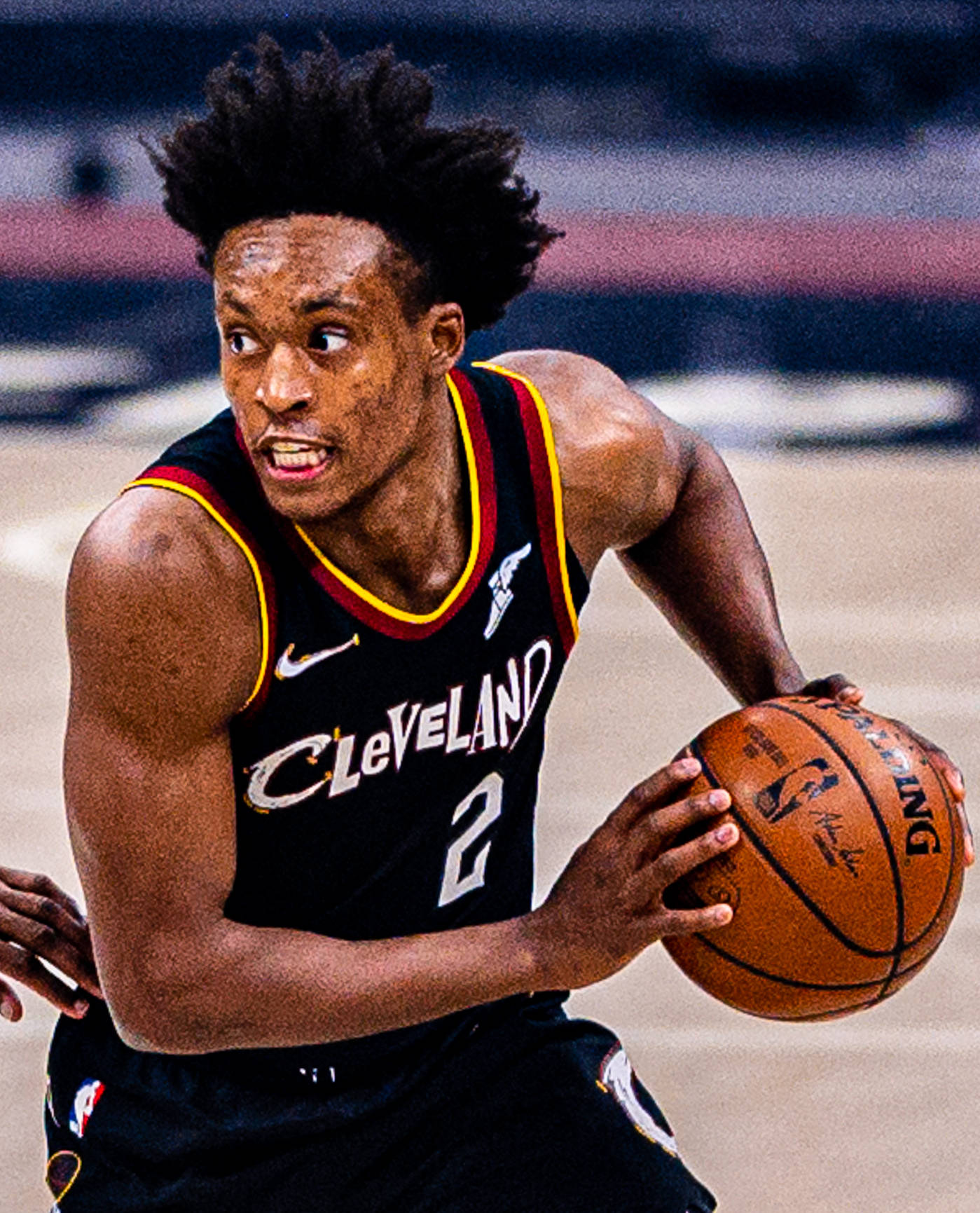 Cleveland Cavaliers 桌布 壁紙 — 一位身穿克里夫蘭球衣的籃球運動員在比賽中專注地運球，充滿決心。