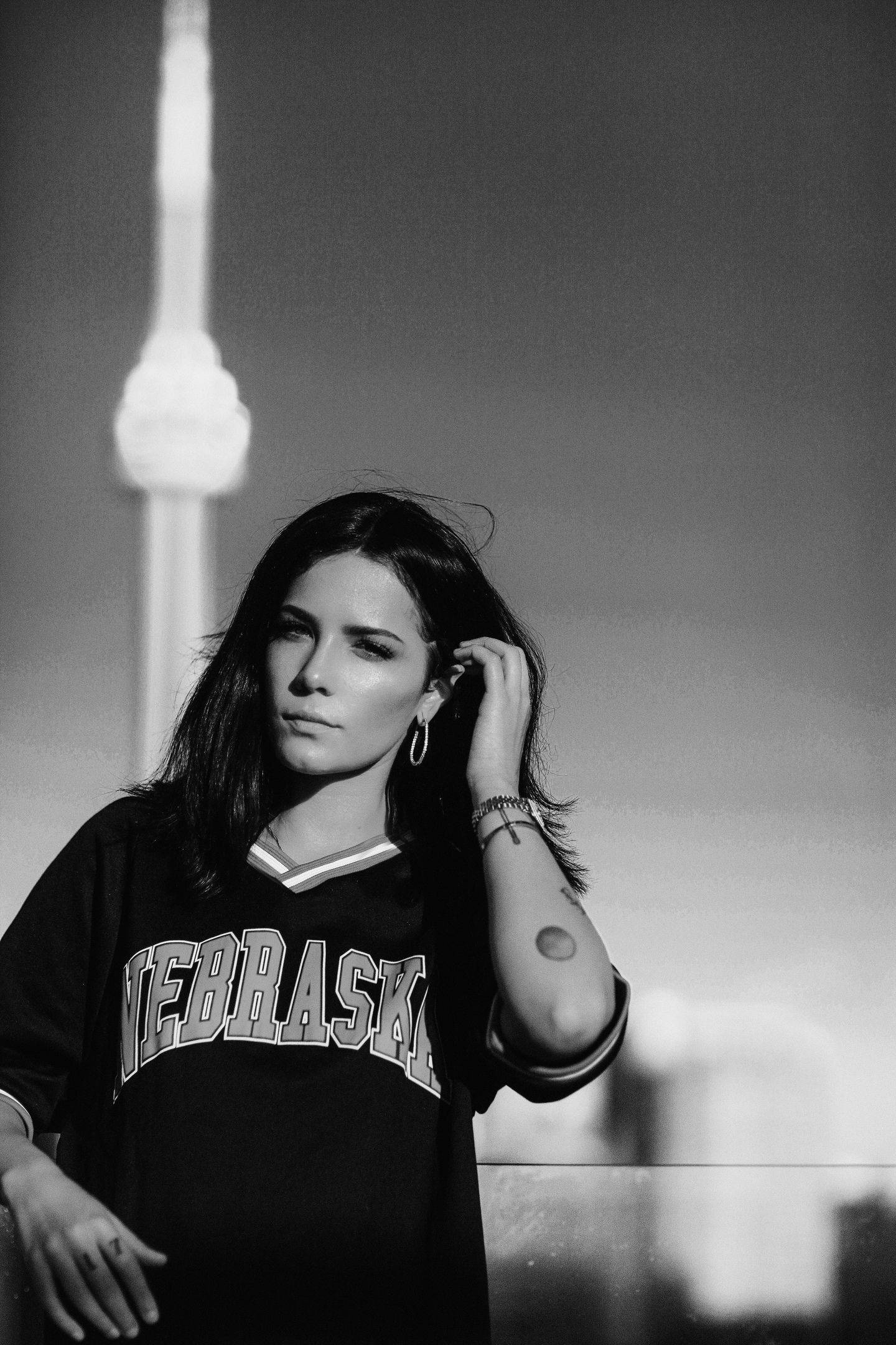Halsey 桌布 壁紙 — 一位身穿內布拉斯加球衣的女性站在多倫多CN塔前，形成一幅引人注目的黑白城市肖像。