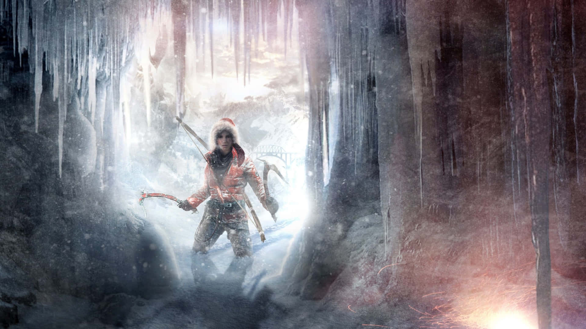 Lara Croft 桌布 壁紙 — 一位身穿冬季裝備的孤獨探險家站在一個冰凍的洞穴中，頭頂懸掛著冰柱，入口處有明亮的光線照射進來。