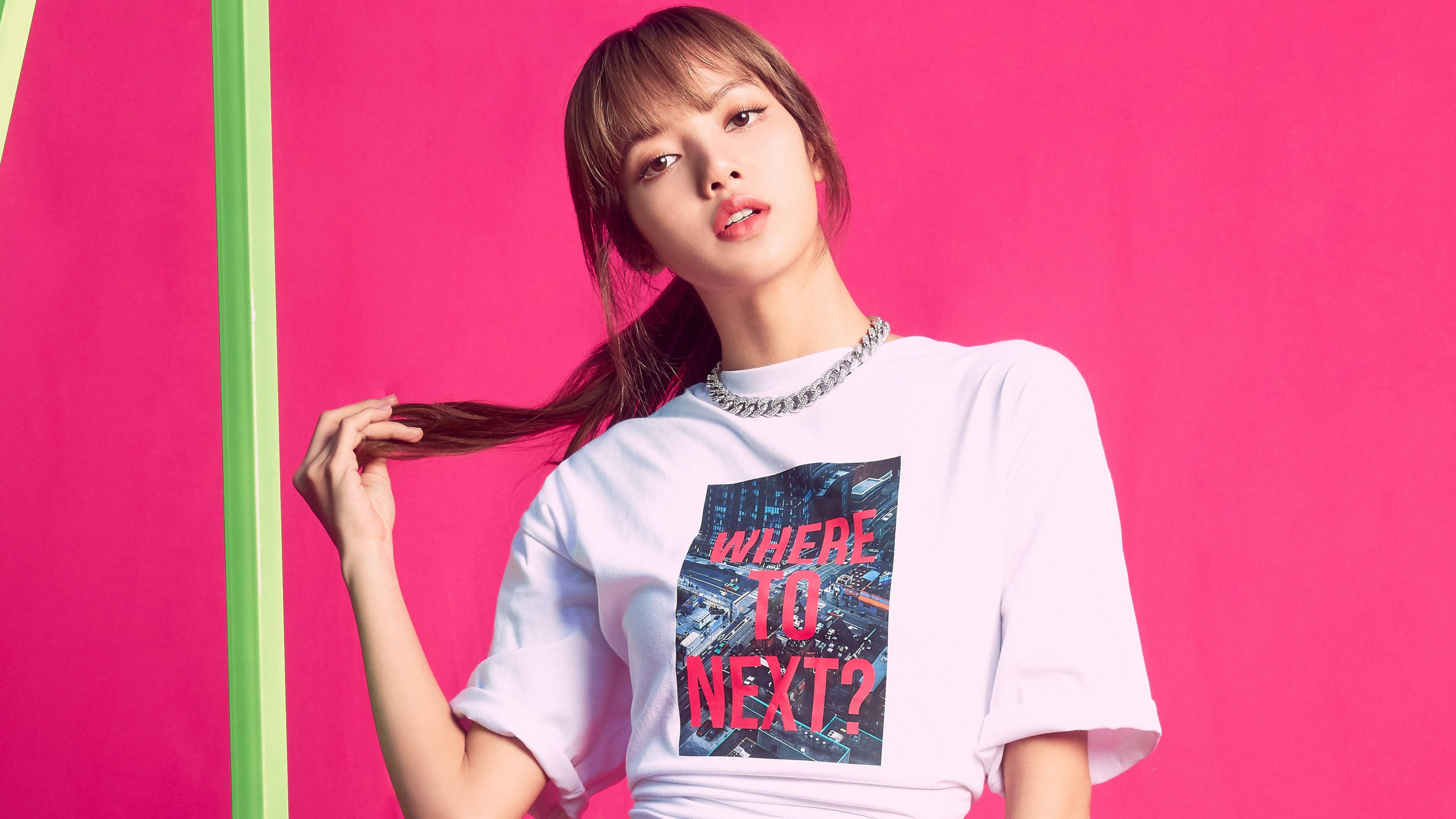 BLACKPINK 桌布 壁紙 — 一位身穿印有城市圖案白色T恤的年輕女性，在充滿活力的粉紅色和綠色背景前擺姿勢。