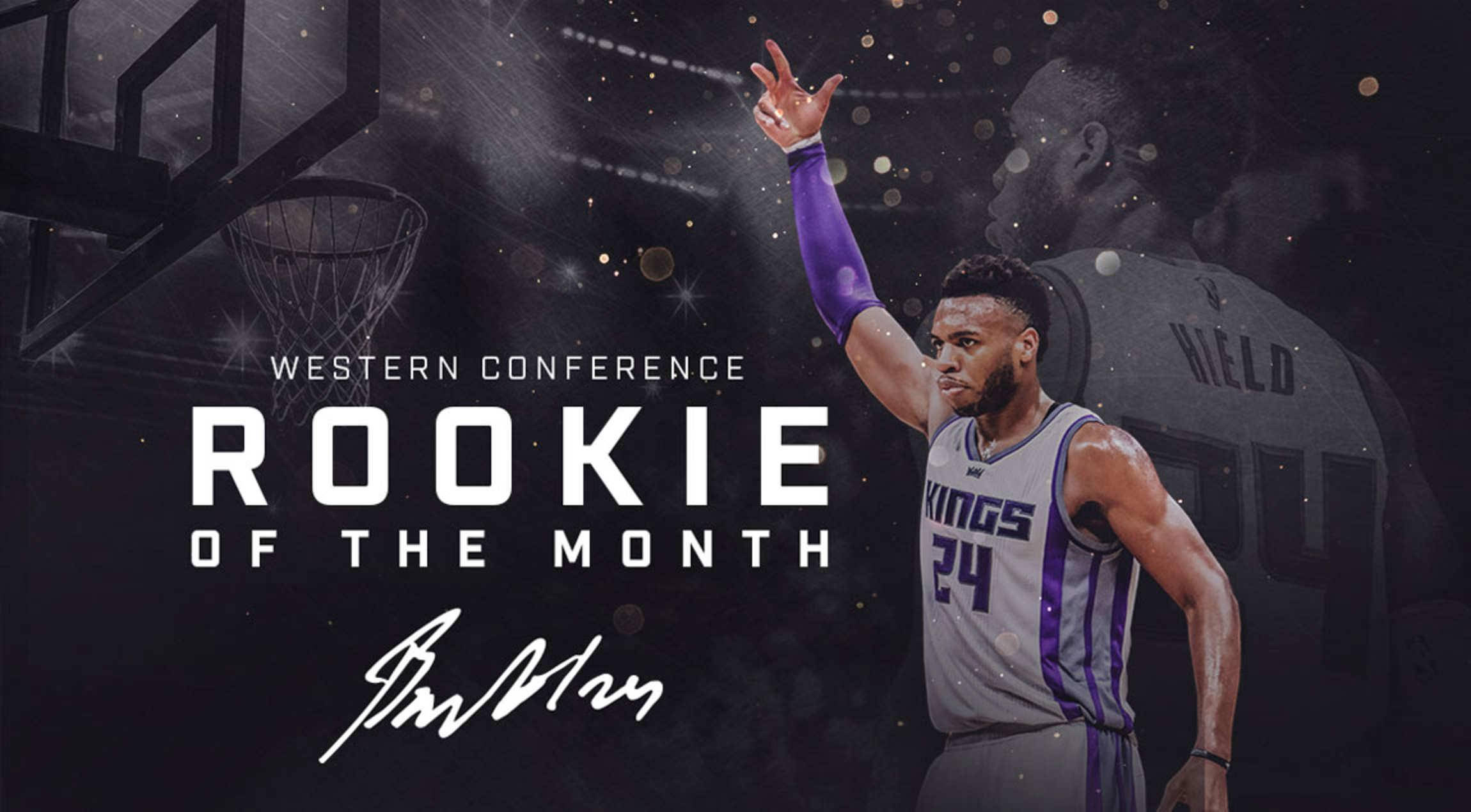 Buddy 桌布 壁紙 — 一位身穿國王隊球衣的籃球運動員舉手慶祝，'Rookie of the Month' 文字在黑暗的球場背景下閃耀。