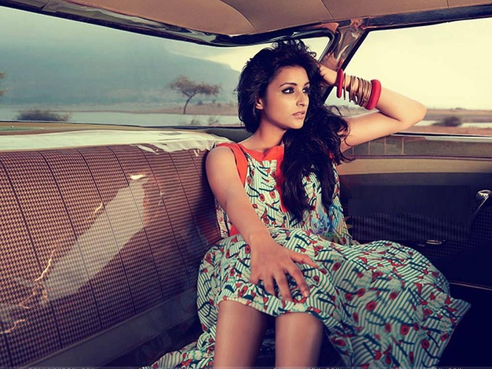Parineeti 桌布 壁紙 — 一位身穿圖案連衣裙的女性自信地坐在一輛擁有千鳥格內飾的復古汽車後座，若有所思地凝視著遠處風景中一棵孤獨的樹。