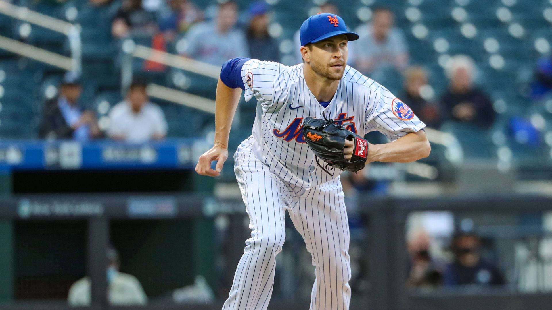 Degrom 桌布 壁紙 — 一位身穿大都會隊球衣的棒球投手在夜間比賽中，於球場燈光下準備投球。