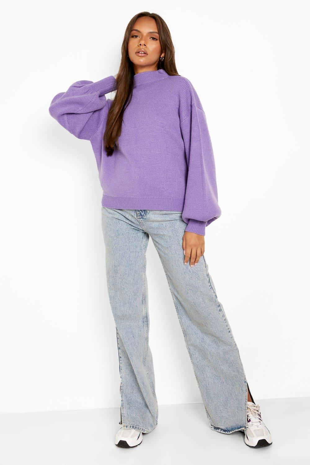 Purple Turtle-neck Sweater 桌布 壁紙 — 一位身穿寬鬆紫色毛衣和寬腿牛仔褲的女性在白色背景前擺姿勢。