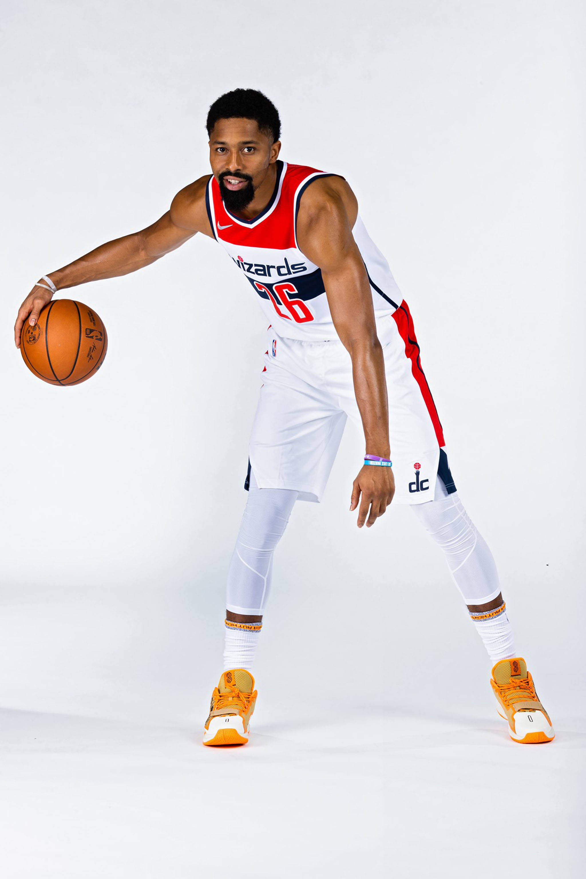spencer dinwiddie 桌布 壁紙 — 一位身穿巫師隊球衣的籃球運動員在白色背景的攝影棚中運球。
