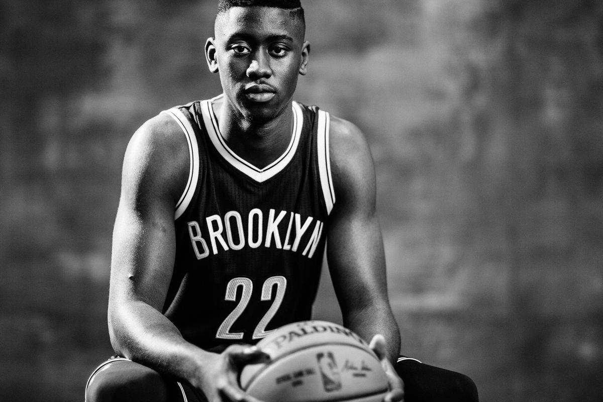 caris levert 桌布 壁紙 — 一位身穿布魯克林球衣的年輕籃球運動員，手持籃球，表情嚴肅的黑白肖像。