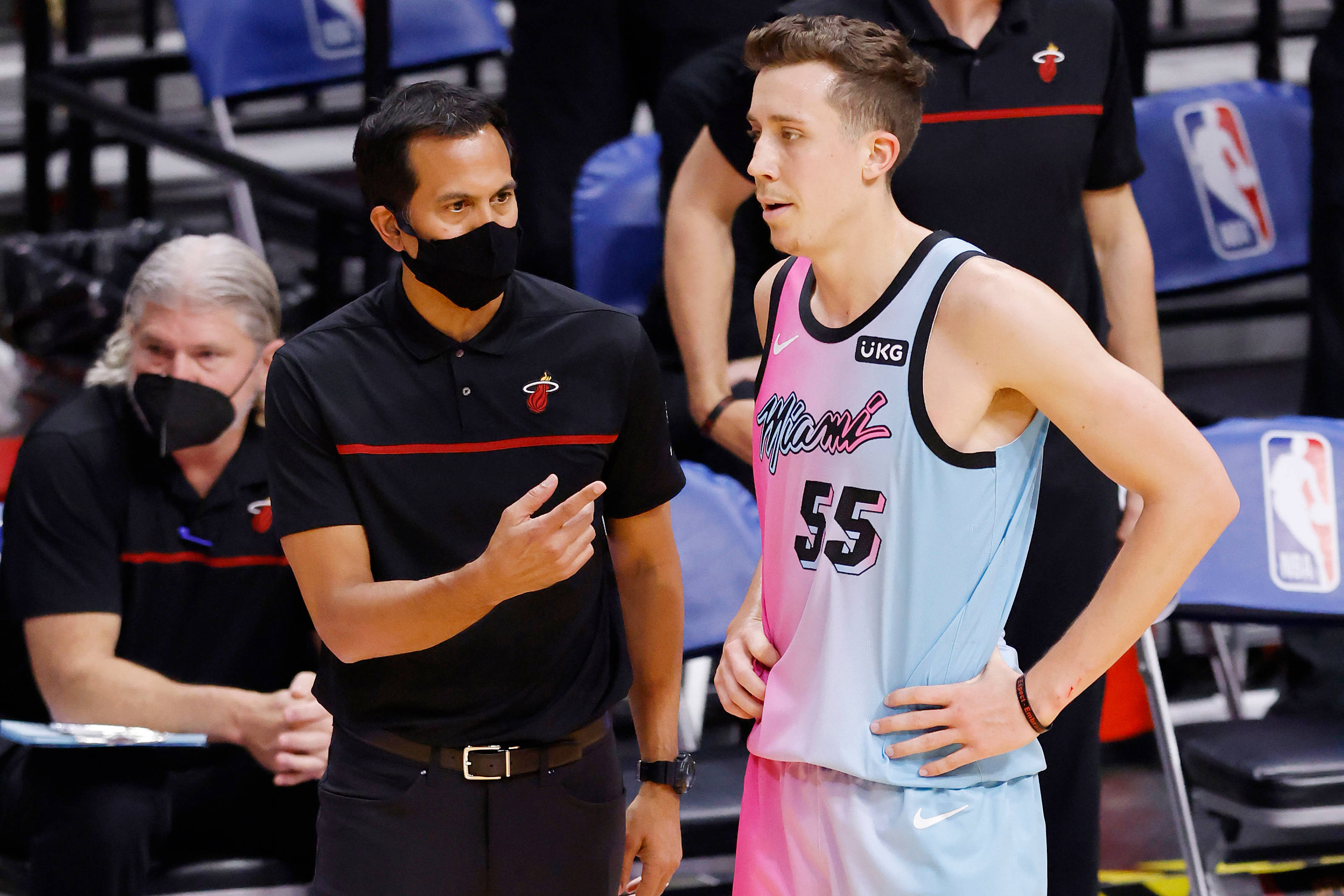 duncan robinson 桌布 壁紙 — 一位身穿帶有紅色條紋的黑色Polo衫的籃球教練，在比賽中向一位身穿粉藍色邁阿密熱火球衣的球員做手勢。