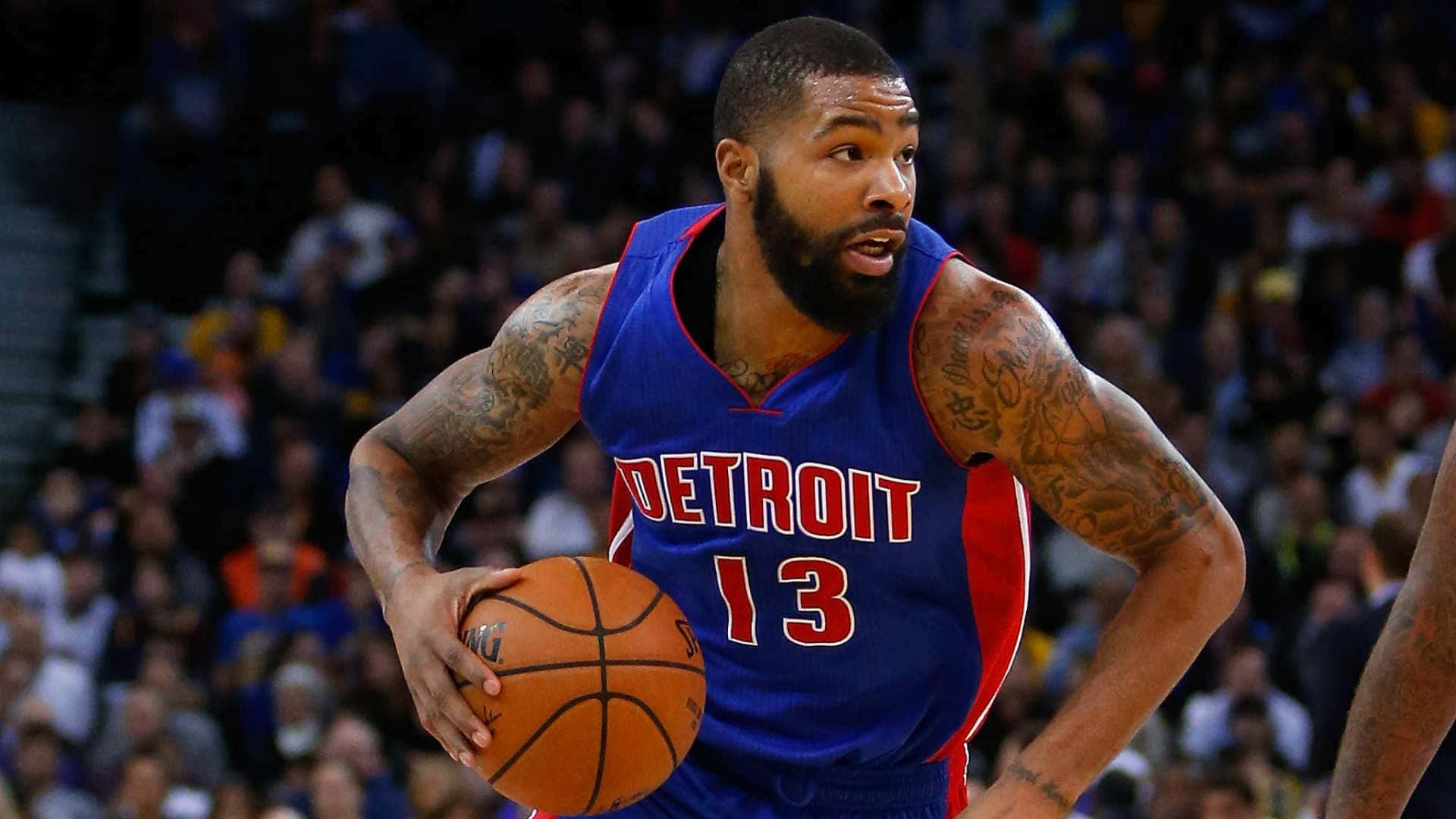 NBA 桌布 壁紙 — 一位身穿底特律活塞隊球衣的籃球運動員在激烈的比賽中運球，背景是模糊的人群。