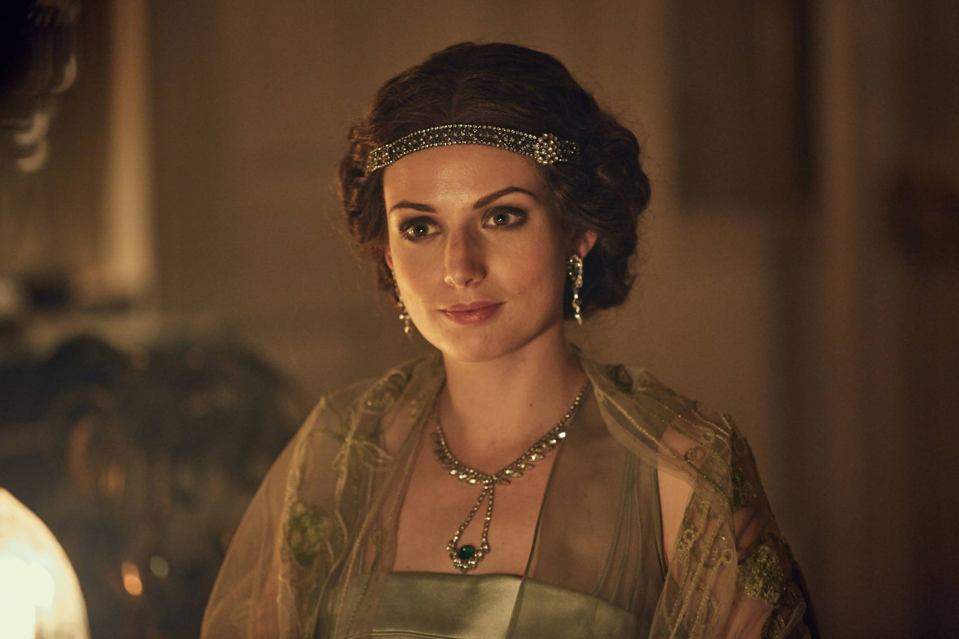在燭光房間中，身穿復古長裙、頭戴珠寶頭帶的女性。 — Peaky Blinders 壁紙