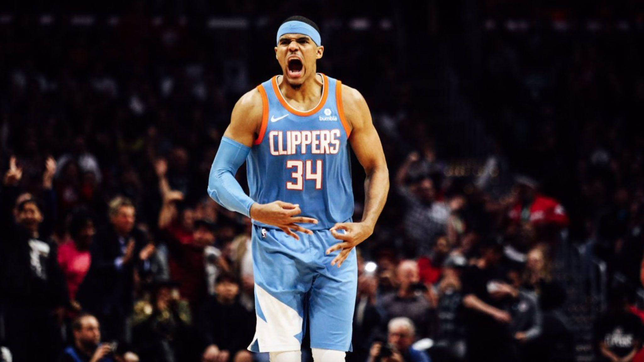 NBA 桌布 壁紙 — 一位身穿快艇隊球衣的籃球運動員在場館燈光下比賽時發出強烈的咆哮。