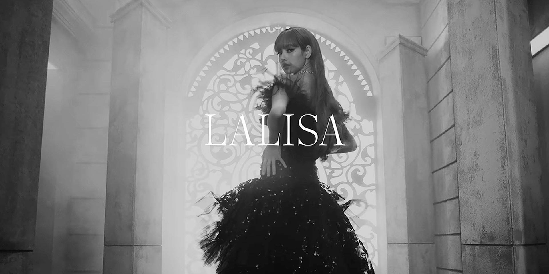 Lalisa 桌布 壁紙 — 一位身穿戲劇性黑色長裙的女性，在霧氣瀰漫的華麗拱門中優雅站立，上面疊加著LALISA的名字。