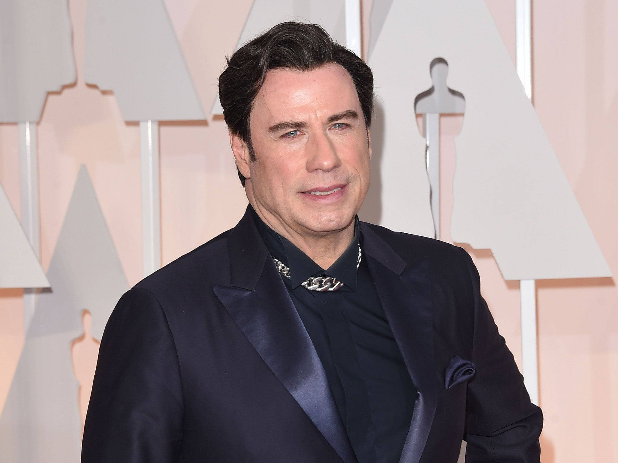 Celebrity 桌布 壁紙 — 一位身穿時尚海軍藍燕尾服、佩戴銀鏈項鍊的男子，在奧斯卡獎盃的背景前自信地站立。