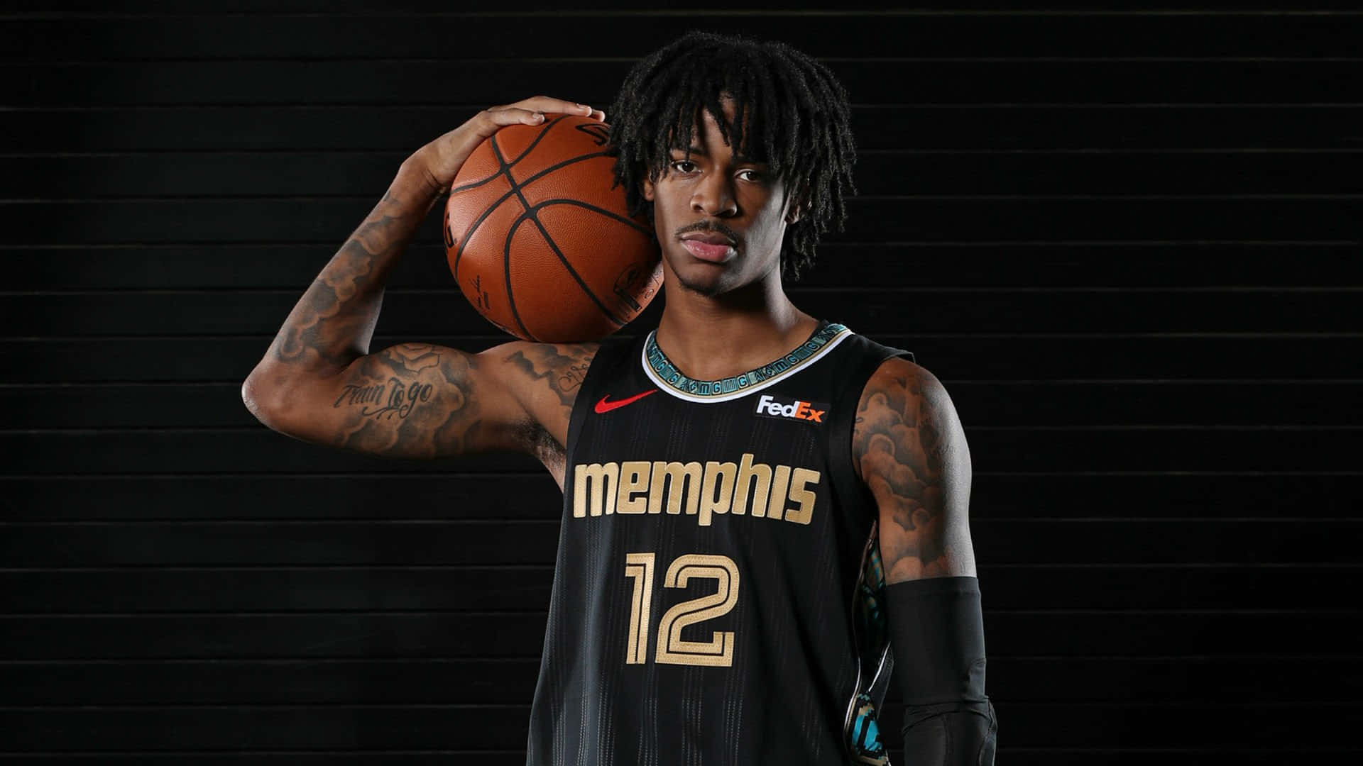 Ja Morant 動圖 桌布 壁紙 — 一位身穿曼菲斯灰熊隊球衣的籃球運動員，在深色條紋背景前持球，刺青清晰可見。