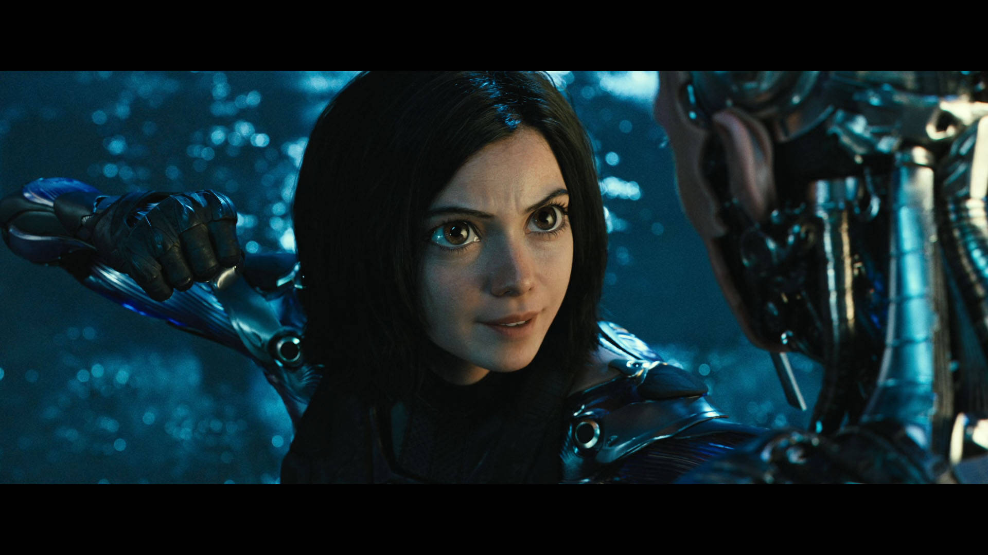 Alita Battle Angel 桌布 壁紙 — 一位身穿未來盔甲的女性，在藍色散景背景下，用發光的眼睛專注地凝視。
