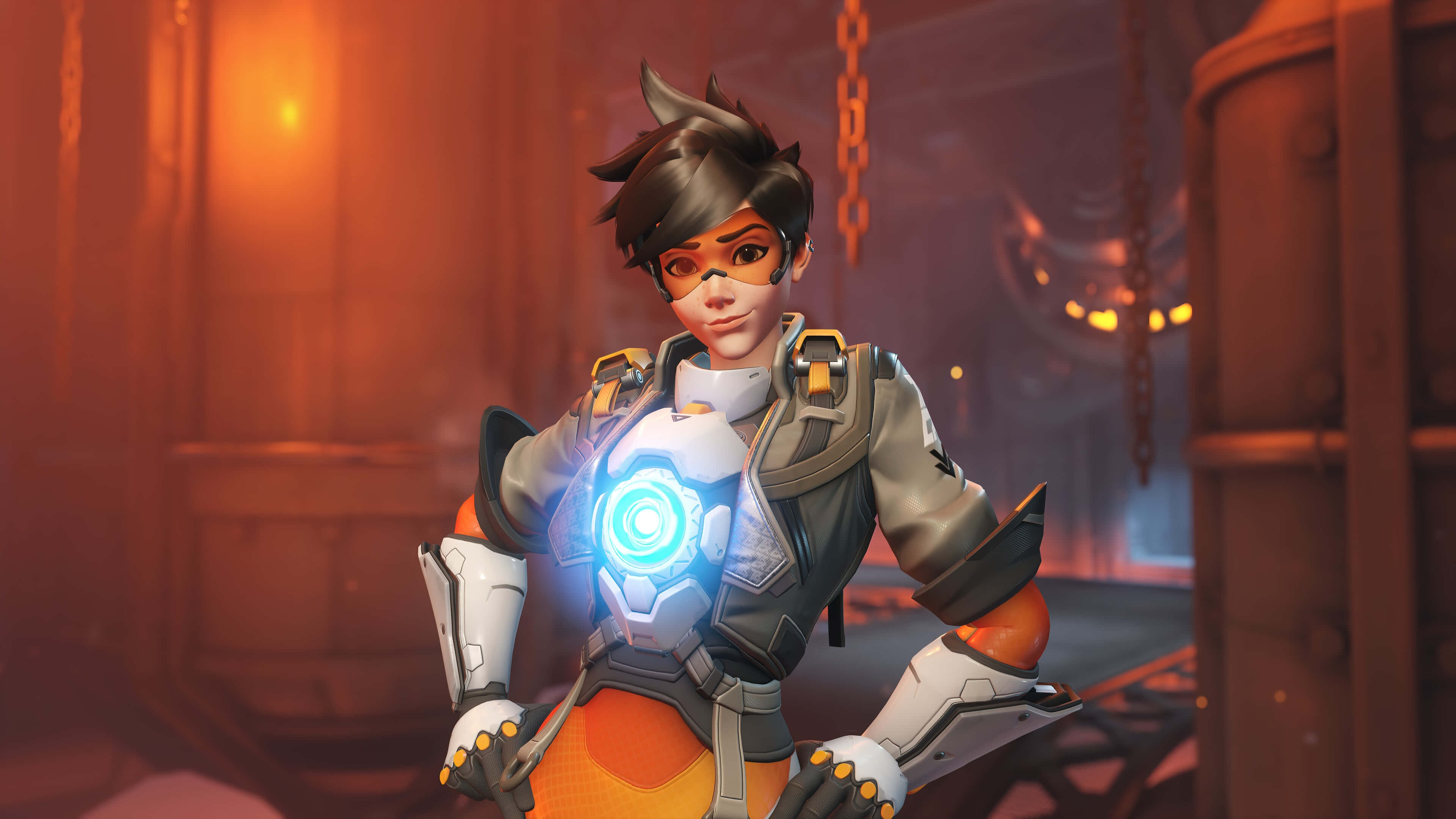 Overwatch Heroes 桌布 壁紙 — 一位身穿未來風格盔甲、胸前帶有發光藍色標誌的女性英雄，自信地站在沐浴在溫暖橙色光線中的工業環境中。
