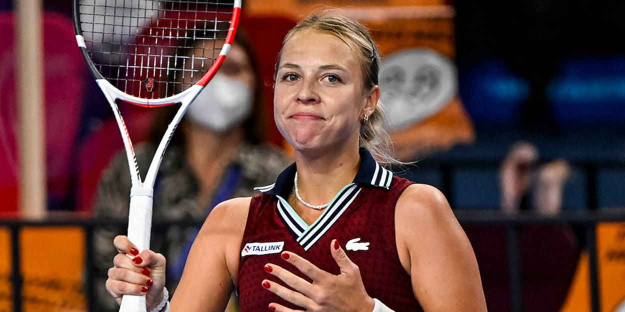 Athletic 桌布 壁紙 — 一位身穿栗色球衣的女網球選手在比賽中手持球拍，手放在胸前微笑。